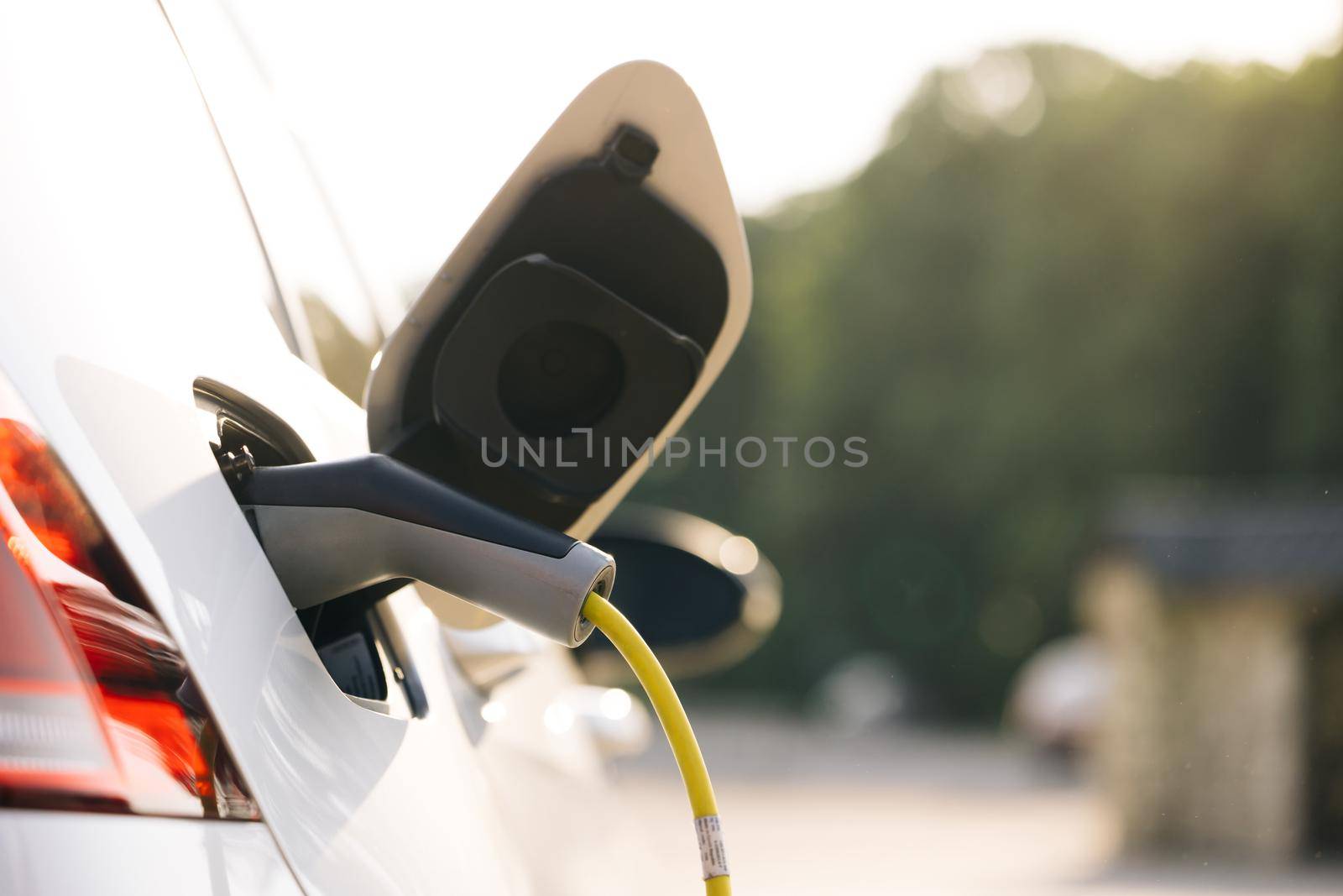 Electric car charging. Electric vehicle charging port plugging in car. Charging technology, Clean energy filling technology by uflypro