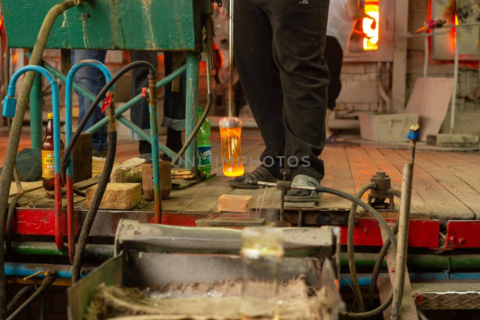 Beryozauka, Belarus - March 07, 2022: A team of glass blowers is working on the manufacture of glass vases and glasses. Up to 20 workers can be involved simultaneously in the production of particularly complex products.