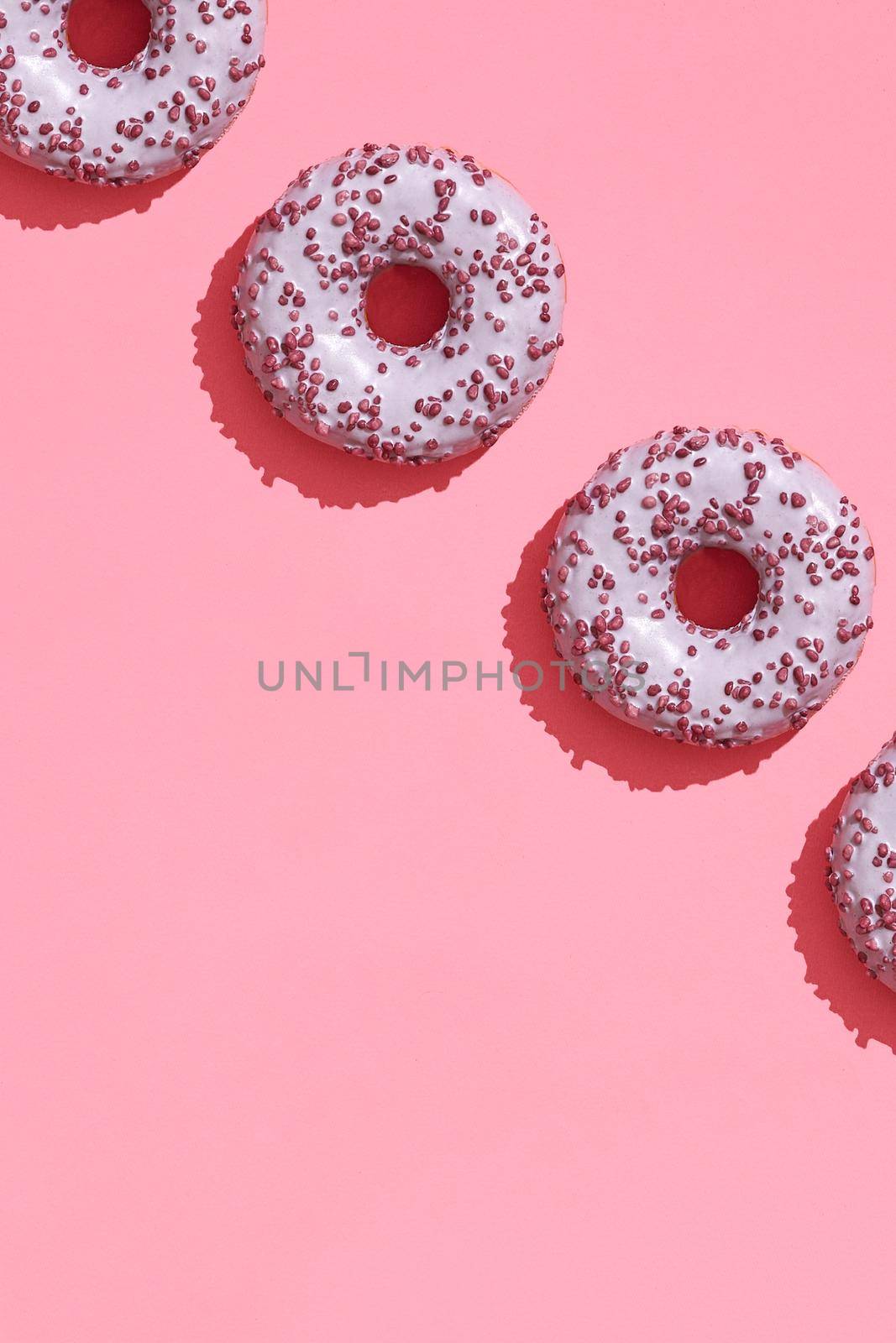 Food design with tasty pink glazed donut on coral pink pastel background top view pattern by nazarovsergey