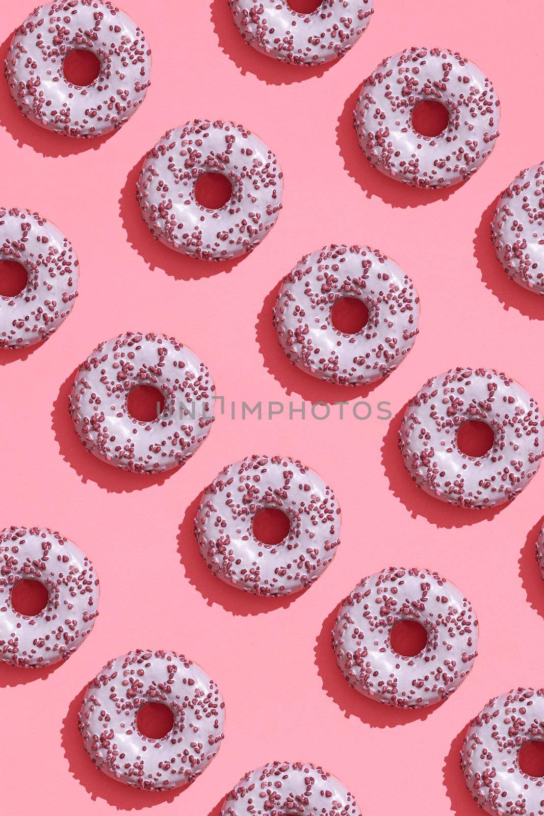 Food design with tasty pink glazed donut on coral pink pastel background top view pattern by nazarovsergey