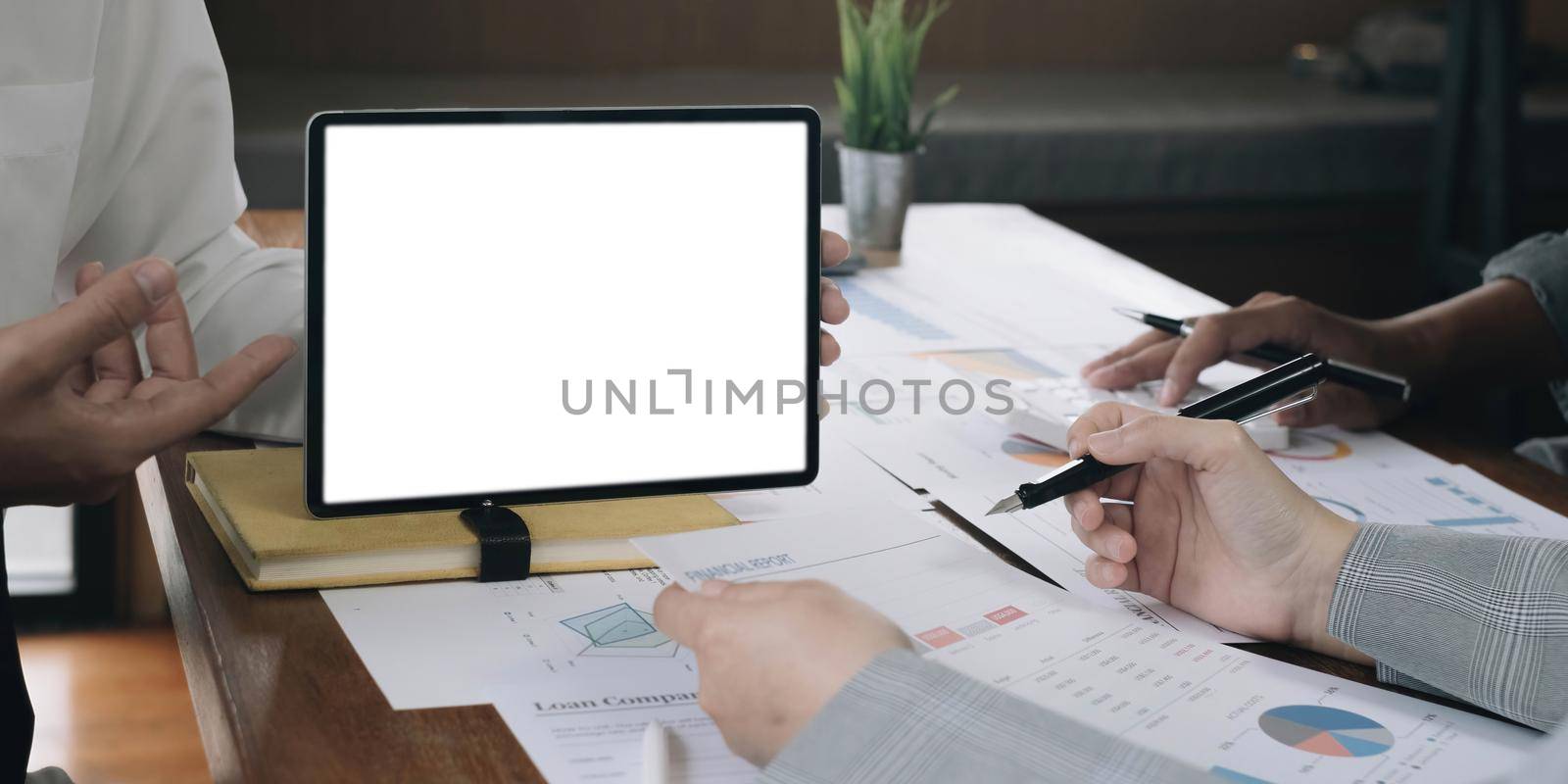 Close up of business team working analysis brainstorm together tablet blank white screen placed at office. Mock up. by wichayada