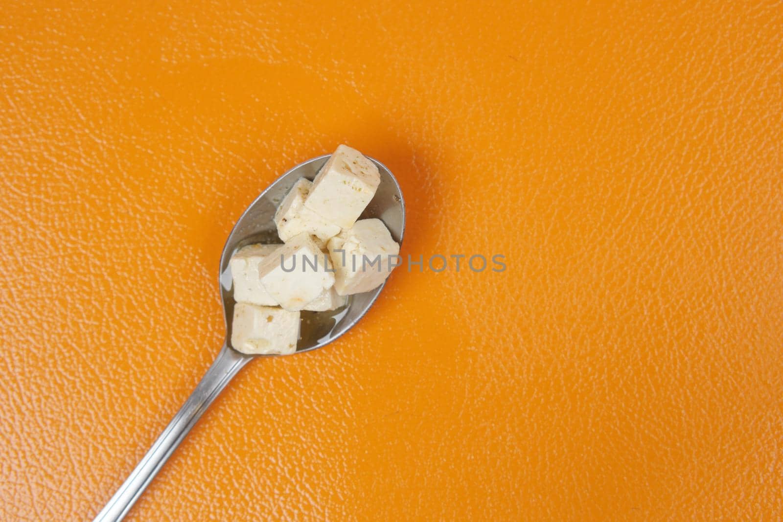 cheese cube on a spoon close up .