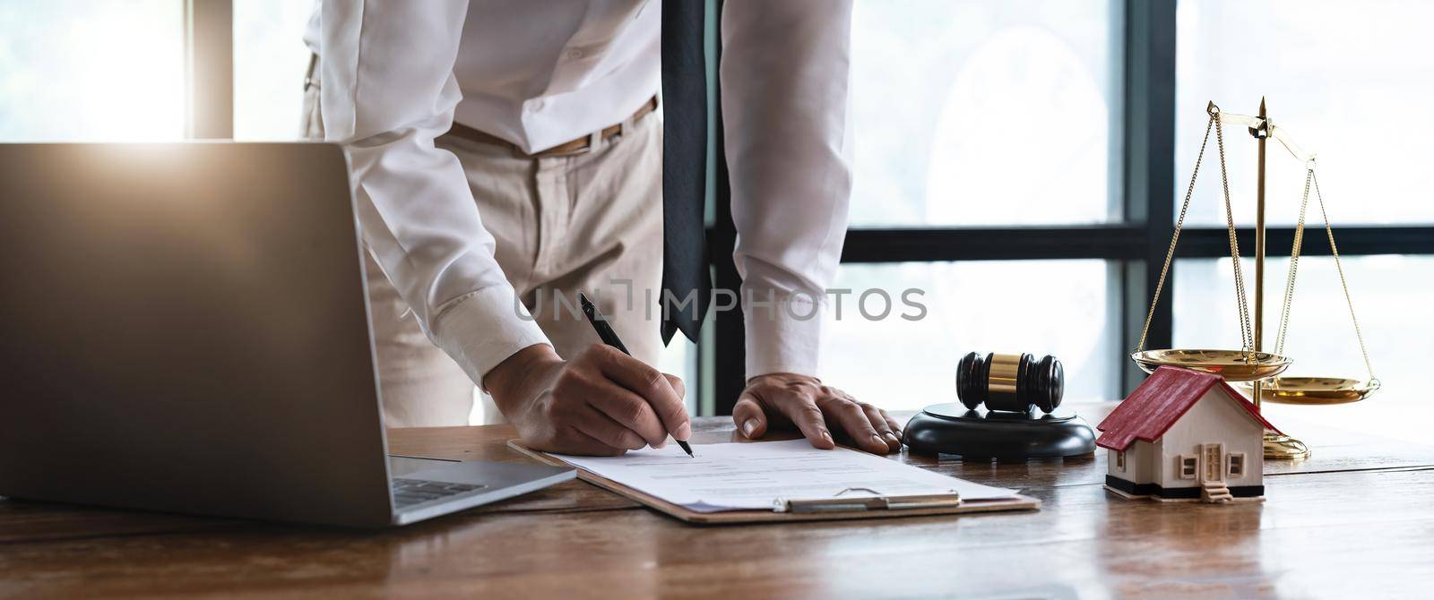 Close up young businessman standing near table with pen in hands, ready signing profitable offer agreement after checking contract terms of conditions, executive manager involved in legal paperwork.. by nateemee