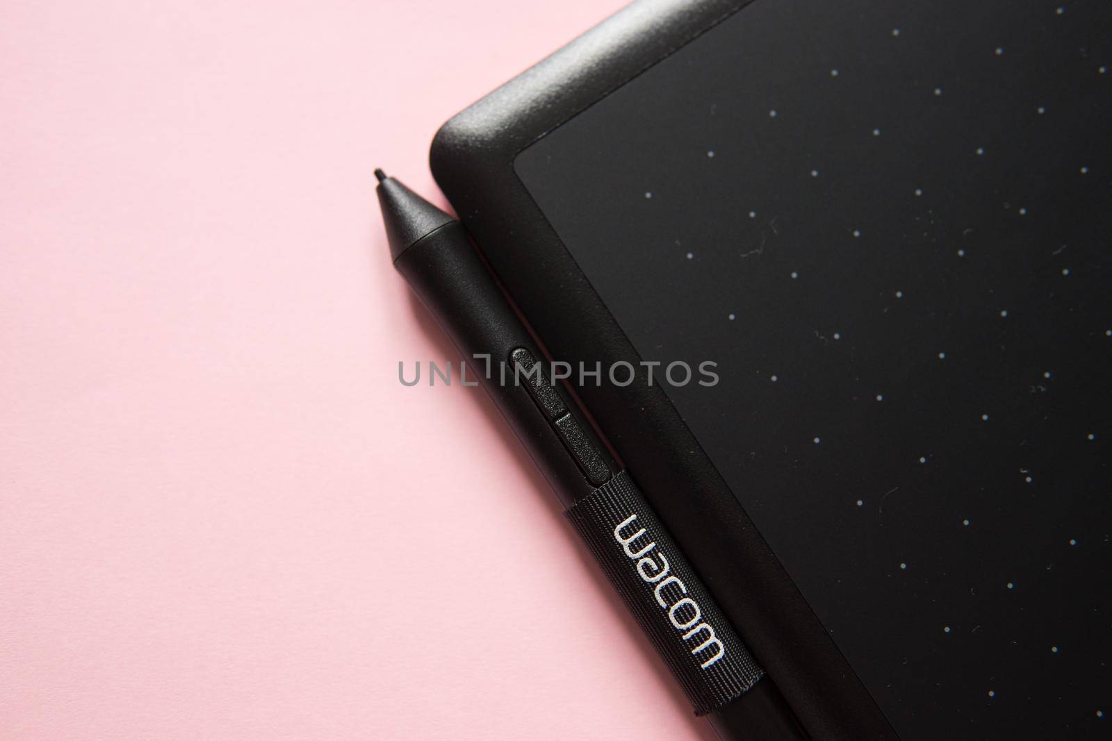 Tver, Russia - February 3, 2020 Top view of Wacom graphic tablet on pink background. Space for text. Selective focus.
