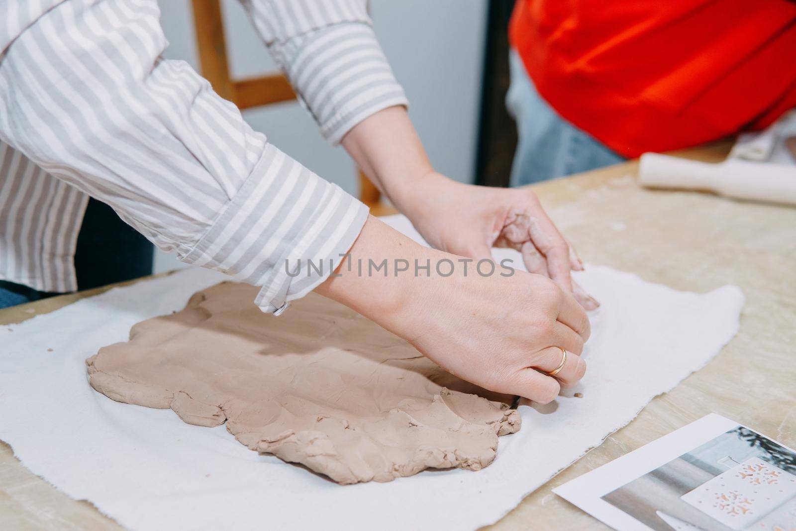 Female hands kneading clay. Production of ceramic products at the master class on ceramics. Close-up.