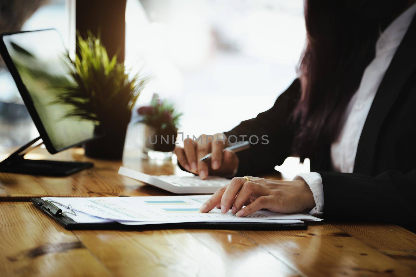 Business woman point to document budget and using calculator to review balance sheet annual to calculating budget. audit integrity before investment