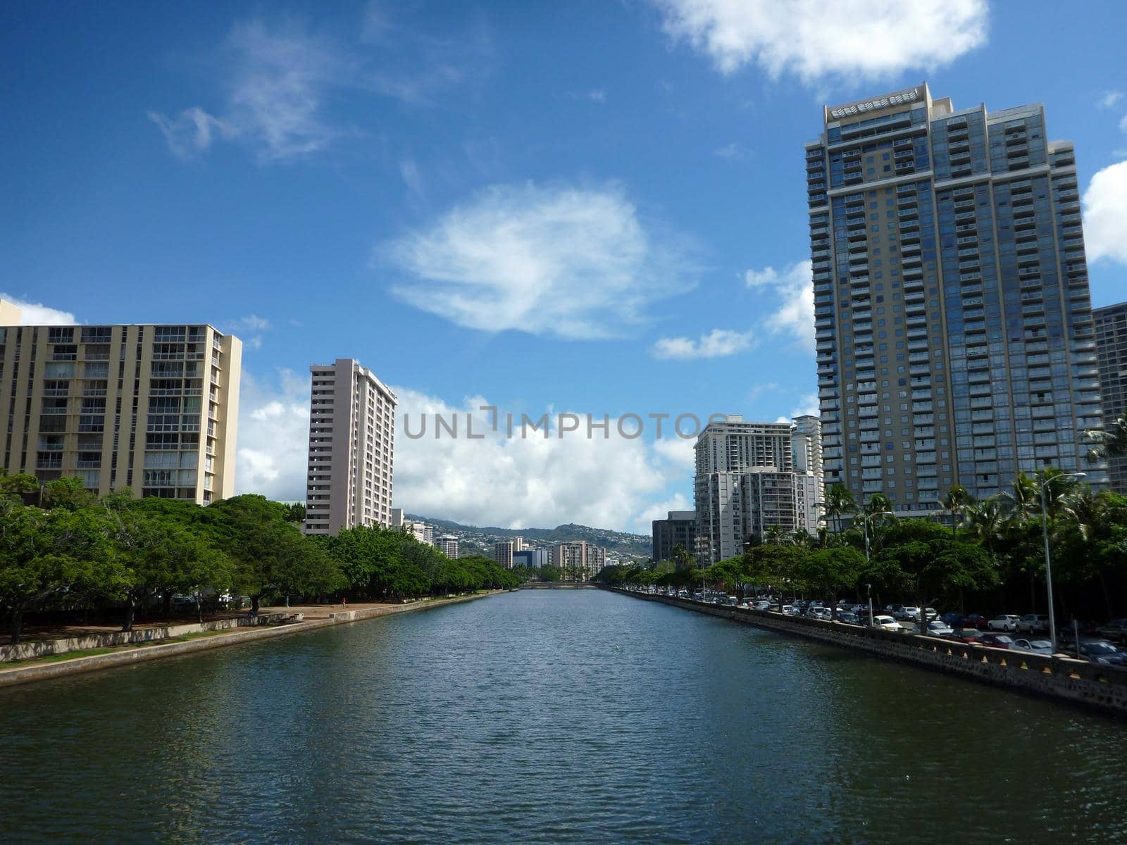 Ala Wai Canal, hotels, Condos, and trees on a nice day in Waikiki on Oahu, Hawaii with mountains in the distance. The Ala Wai Canal is an artificial waterway in Honolulu, Hawaii which serves as the northern boundary of the tourist district of Waikīkī. It was created in 1928 for the purpose of draining the rice paddies and swamps which would eventually become the tourist resort area of Waikiki. It also serves as a primary drainage corridor for the rivers and streams that run through central and east Honolulu.