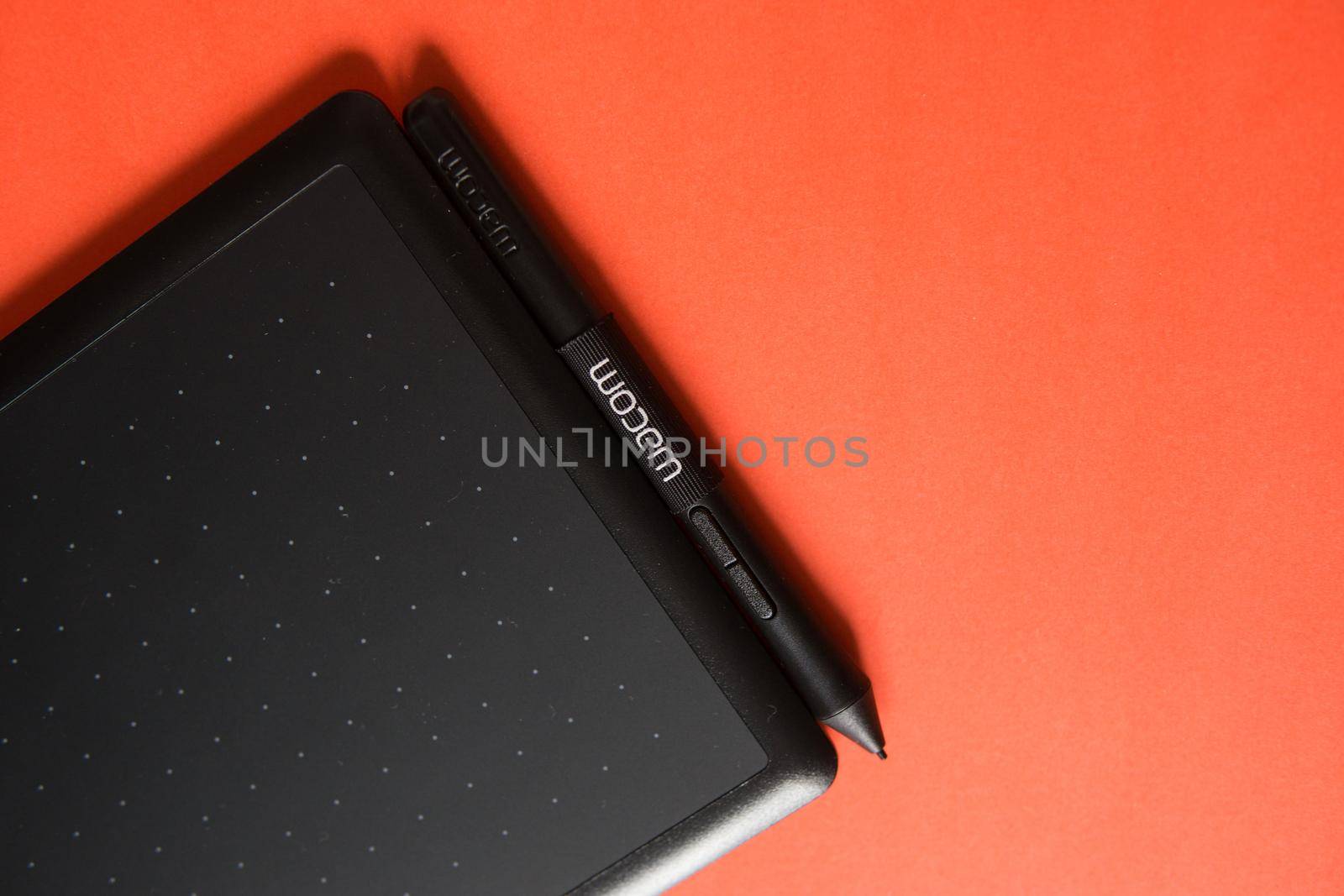 Tver, Russia - February 3, 2020 Top view of Wacom graphic tablet on red background. Space for text. Selective focus.