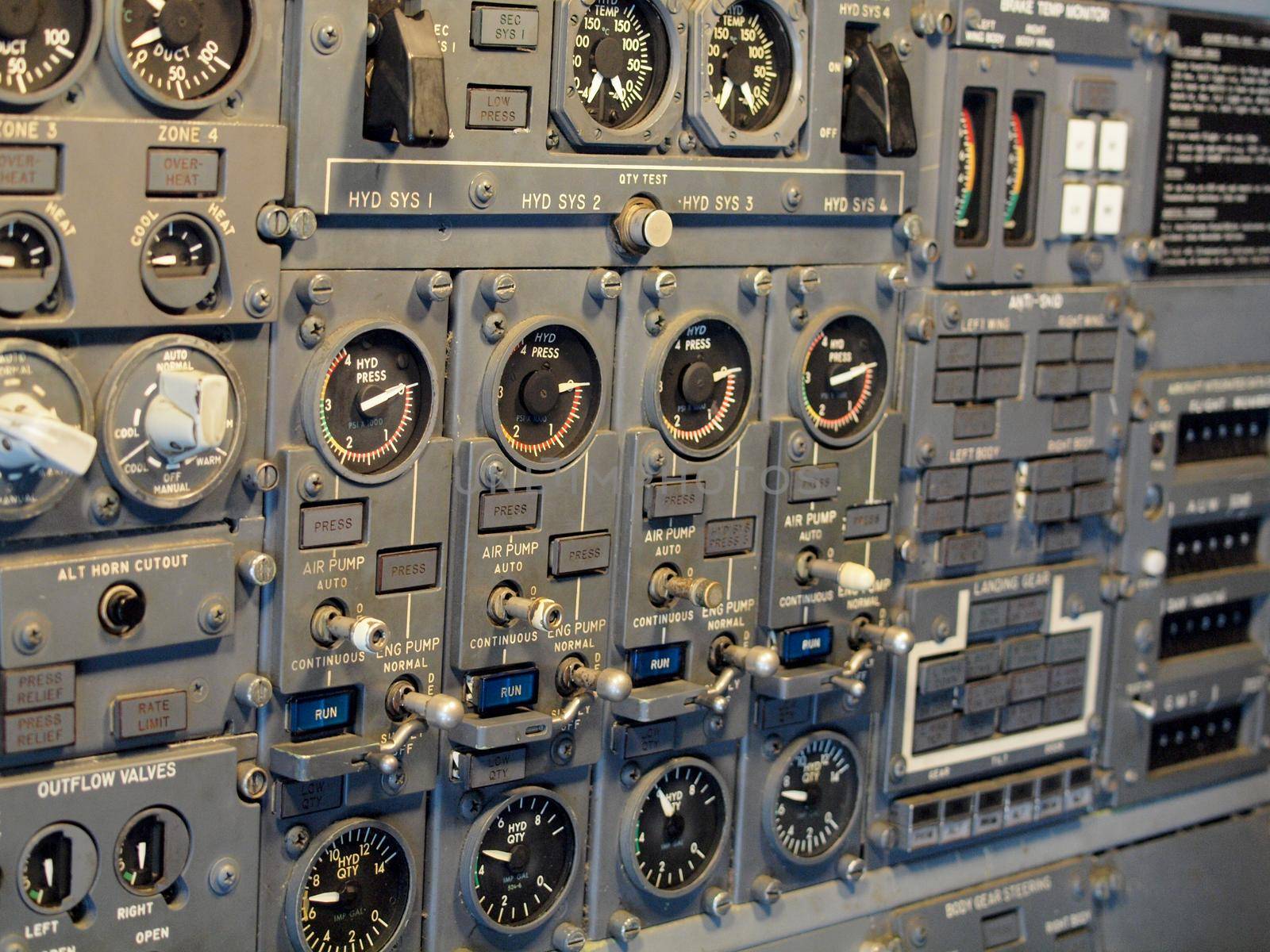 Jet aircraft cockpit Equipment with various indicators, buttons, dials, and instruments.