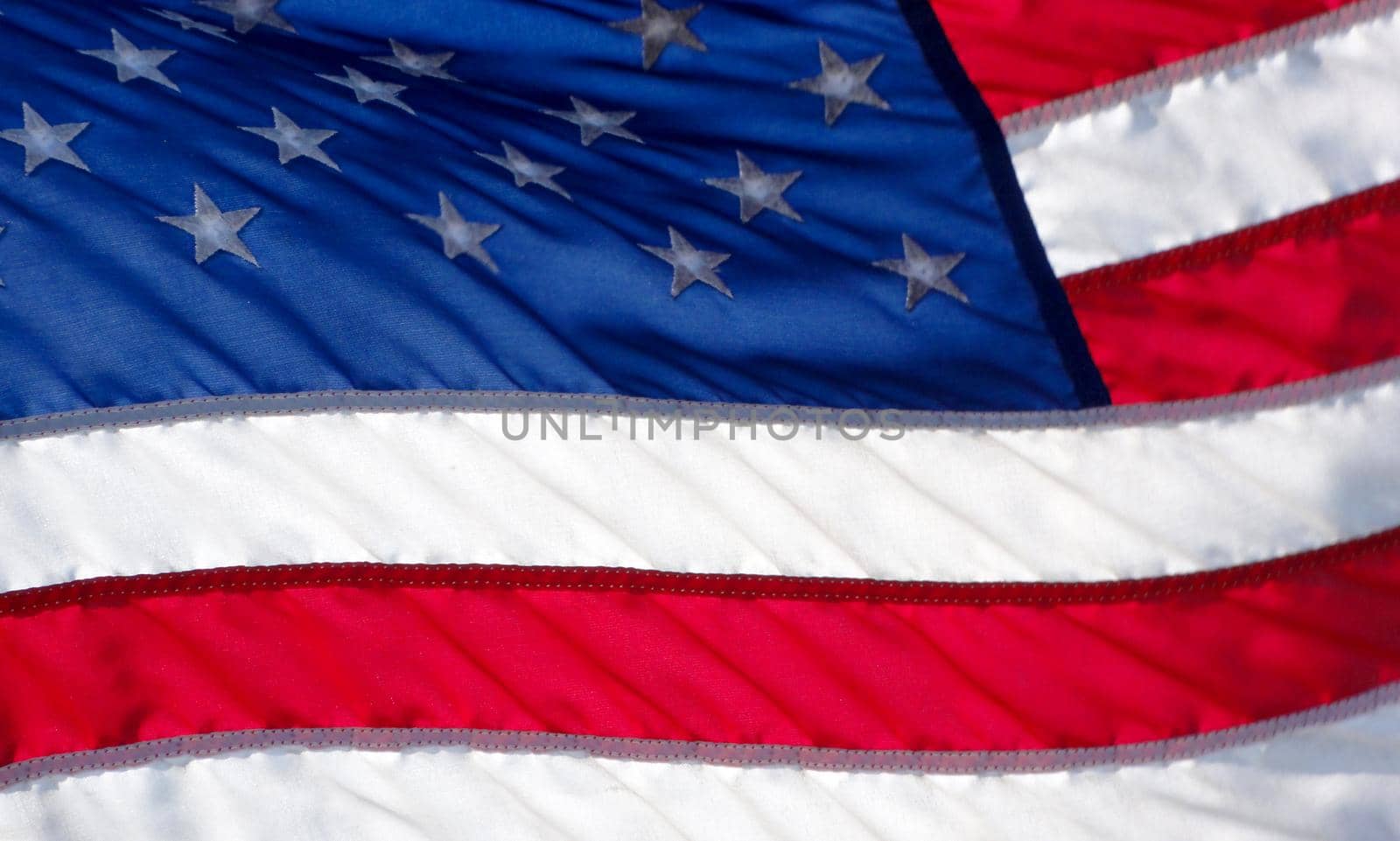 USA Flag waves in the wind with light illuminating the cloth.