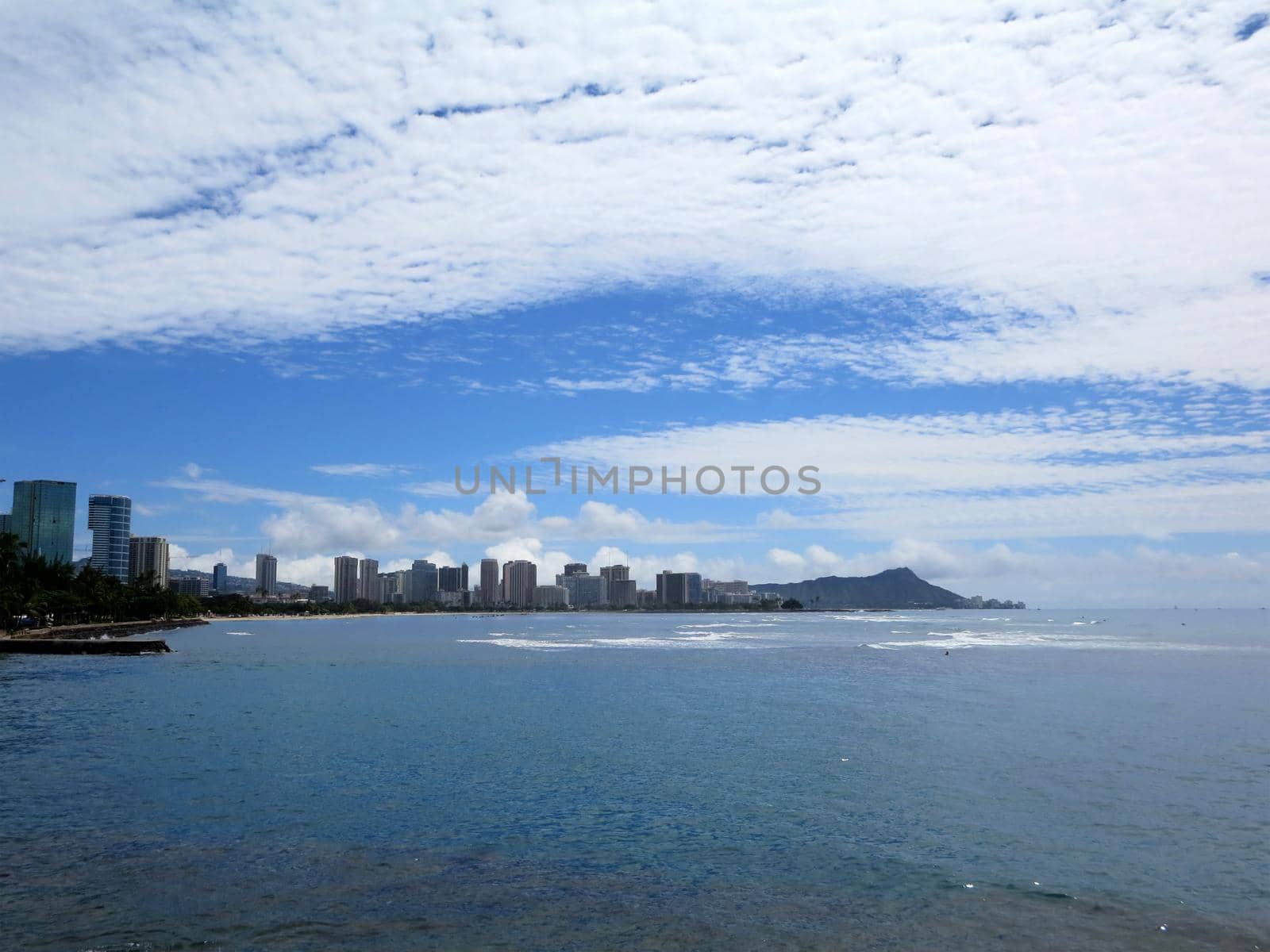 Ala Moana Beach Park with buildings of Honolulu, Waikiki and iconic Diamondhead in the distance during a beautiful day on the island of Oahu, Hawaii.