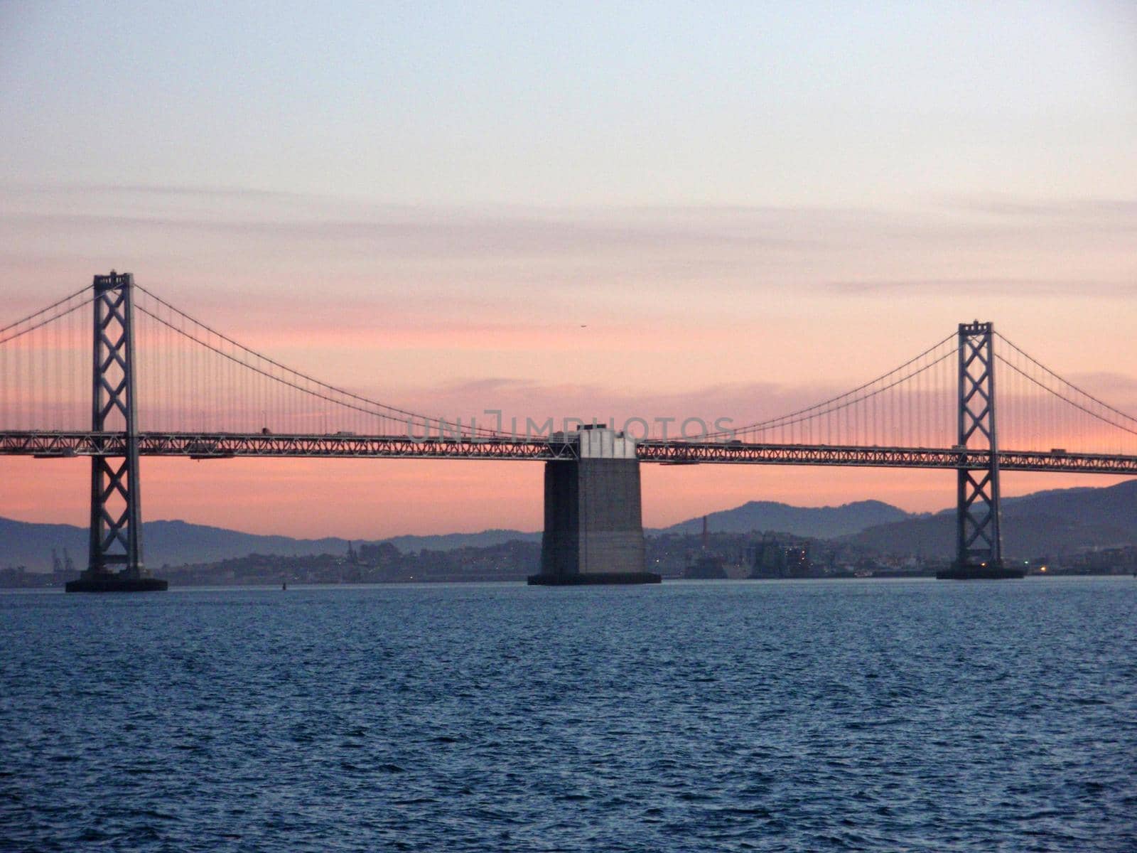 Center of San Francisco Bay Bridge at Dusk with city in the background.