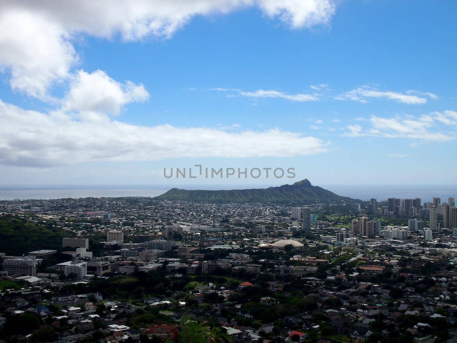 Diamondhead and the city of Honolulu on Oahu on a nice day with a few clouds in the sky. UH Manoa, Waikiki, Kahala and the H-1 Visible, seen from Round Top Dr. lookout point.
