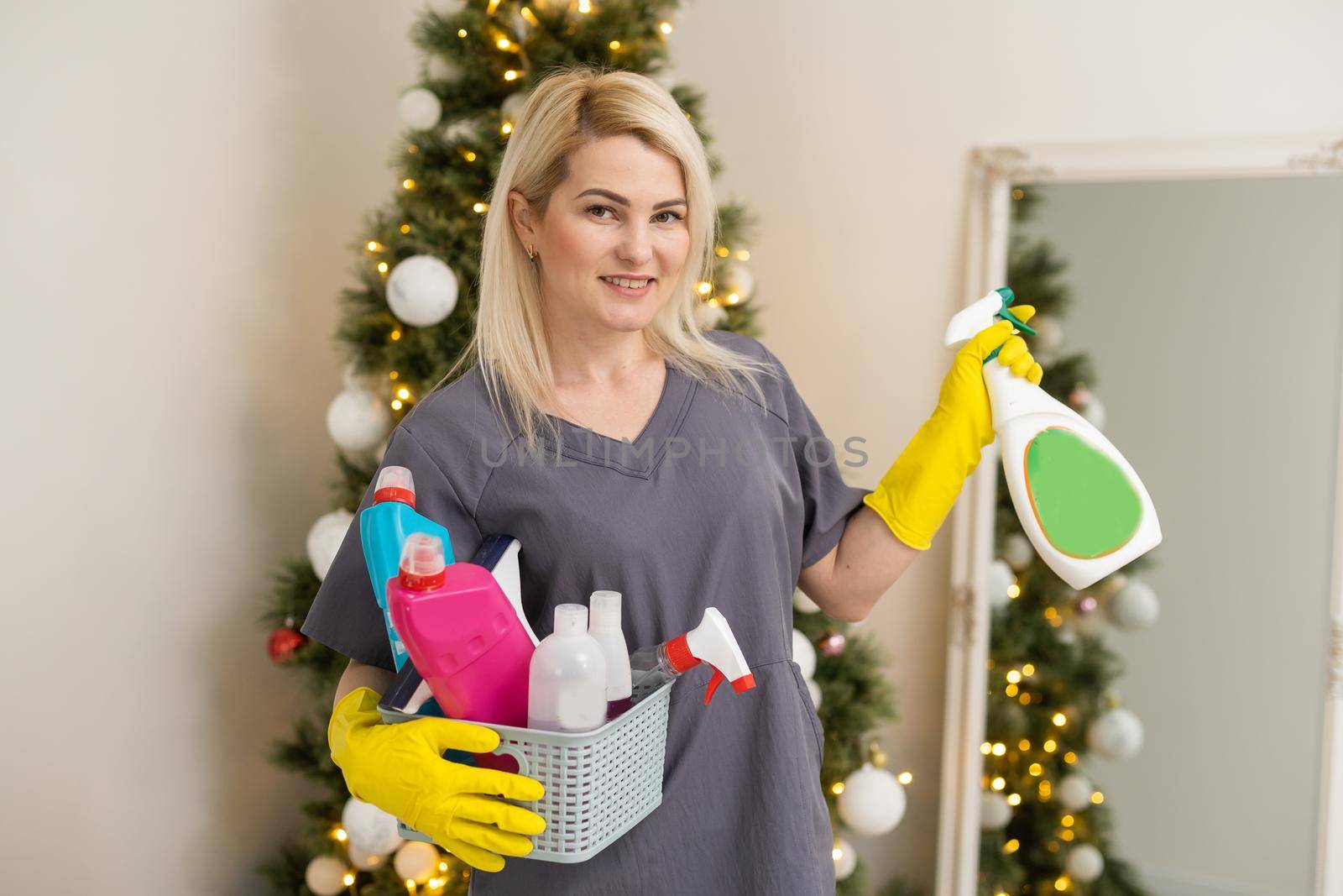 Portrait of attractive young woman wiping table before Christmas celebration