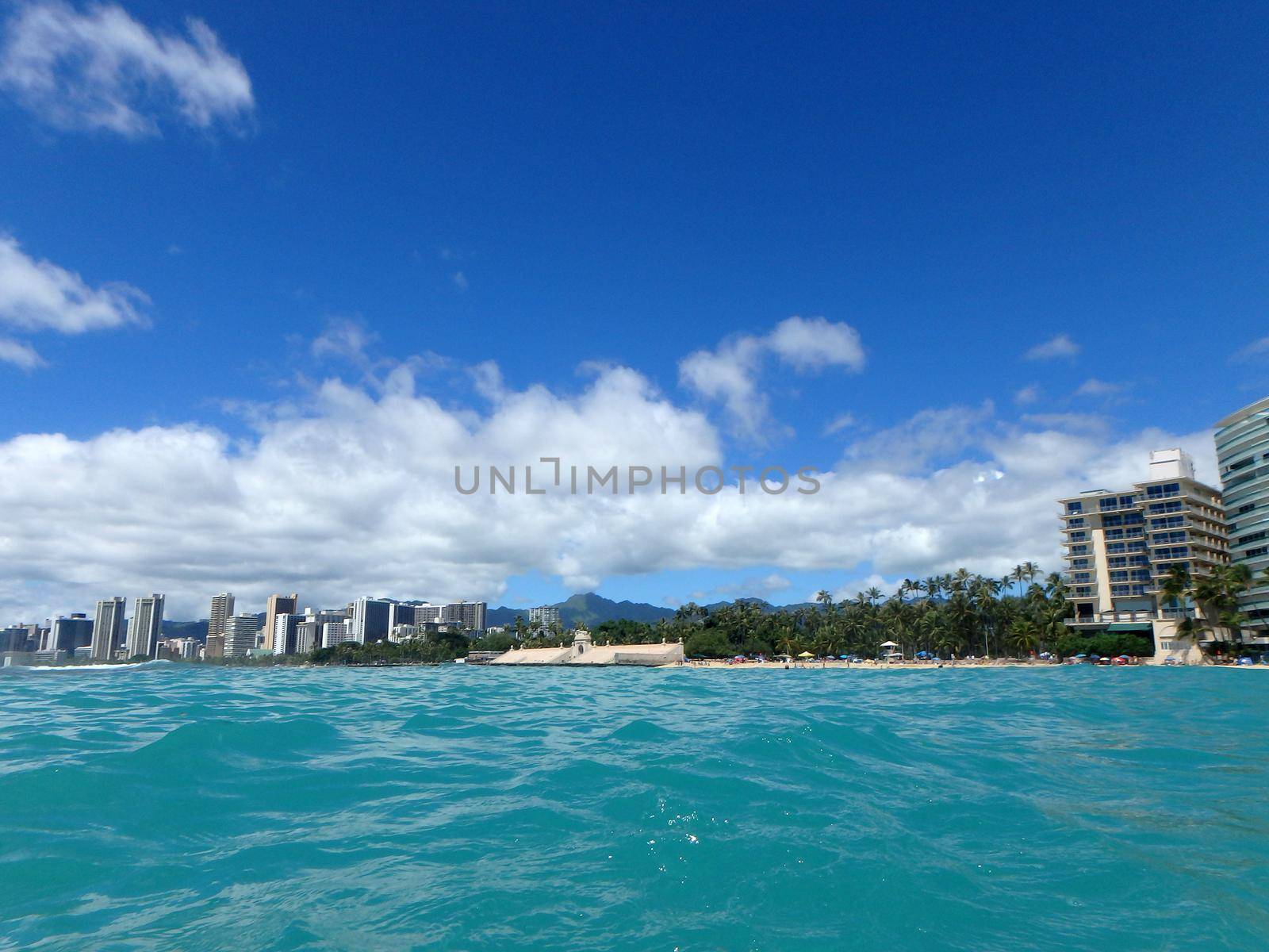 Historic Natatorium, Waikiki, Condomiums, Honolulu cityscape and San Souci Beach, coconut trees and lifeguard tower on a nice day Oahu, Hawaii seen from the water.  