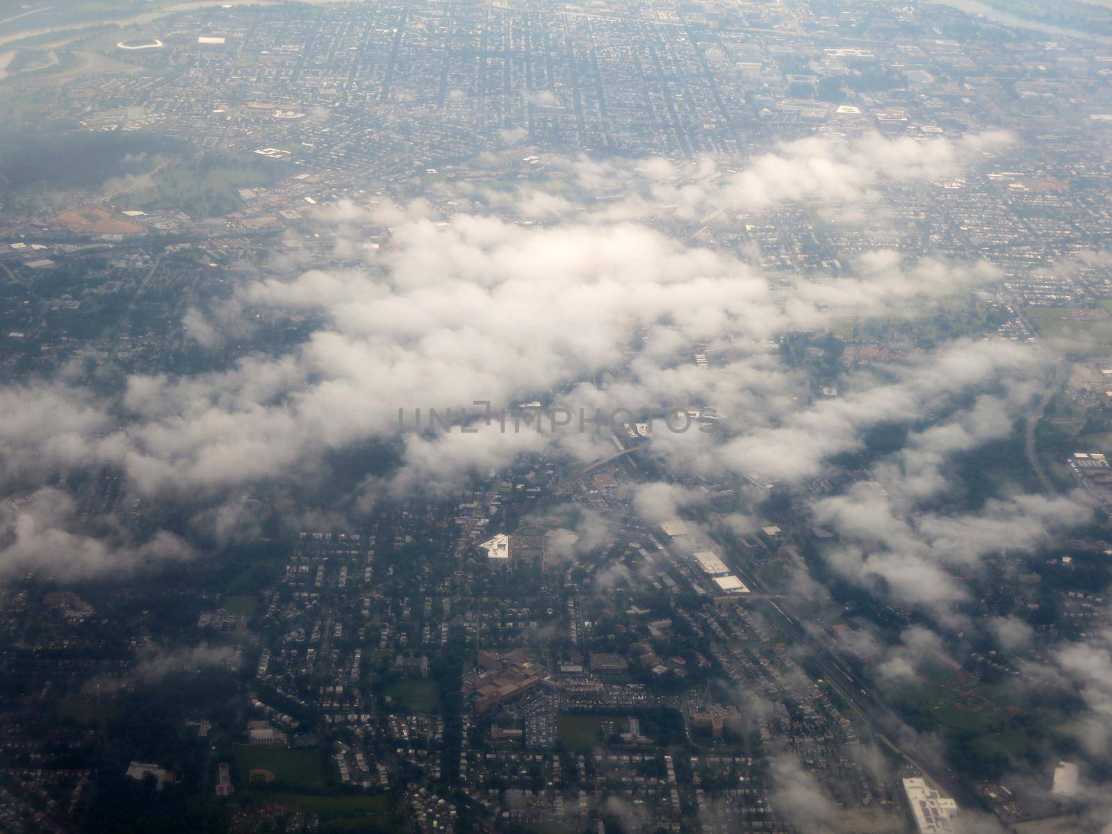 Clouds hover over Washington DC area aerial cityscape.                               