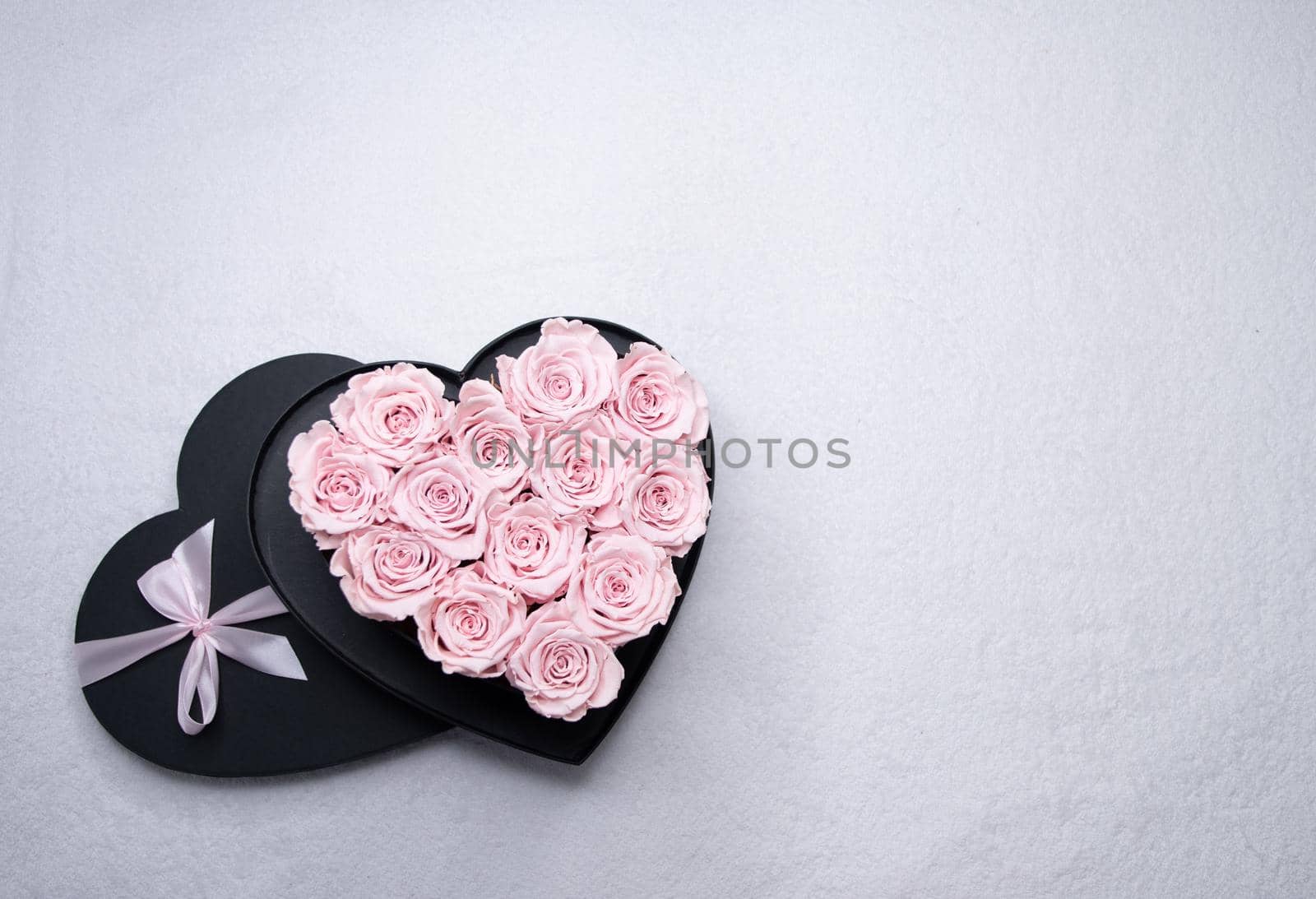 heart-shaped cardboard box with pink roses on the table, a gift for valentine's. High quality photo