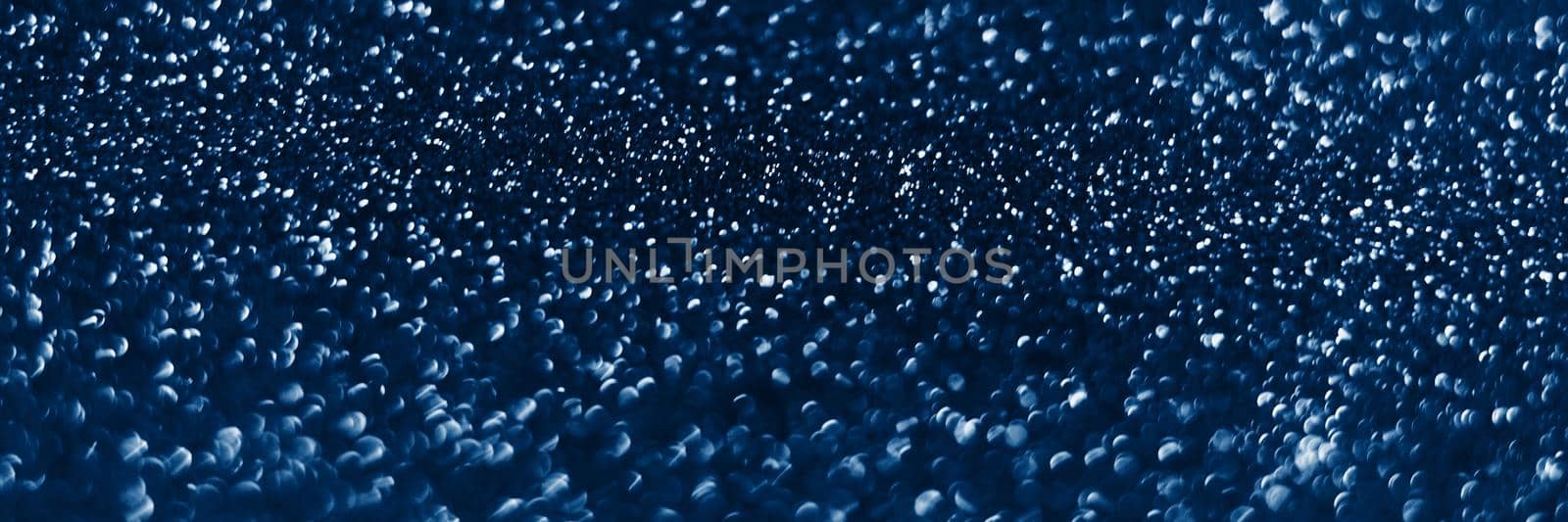 Glowing sparkles on blue color trendy background. Holiday bright brilliant beautiful background, template for blog or designers. Web banner. New Year .