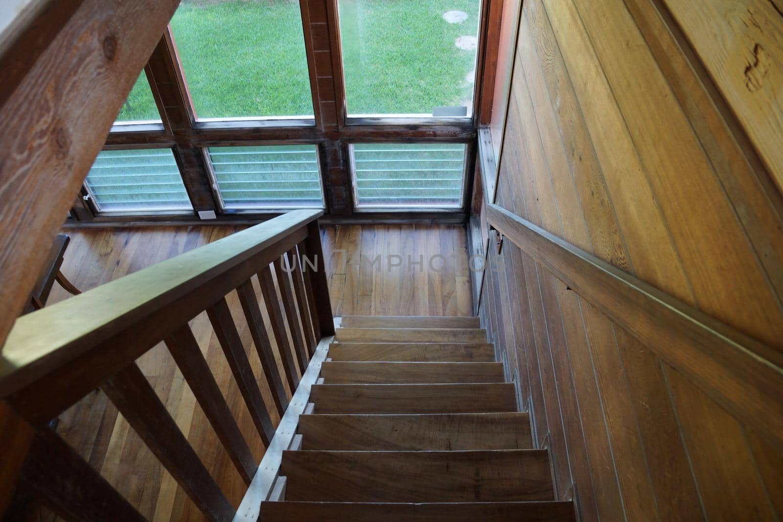 Wood Staircase leading downstairs to the dinning room with large windows featuring views of outside

