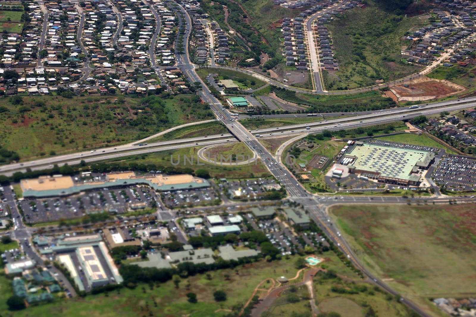 Aerial of Highway interchange, Kapolei homes, shopping centers, and quarry on the west side Oahu, Hawaii on a beautiful day.