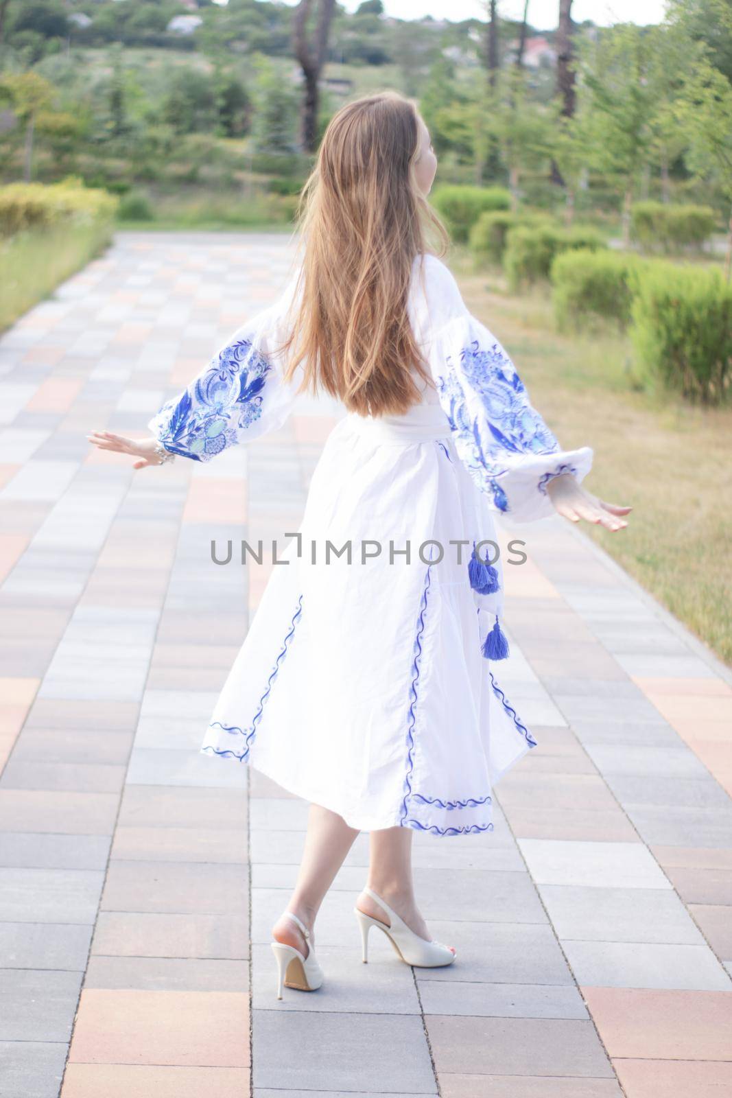 ukrainian blonde girl in national blue dress - embroidered shirt. young woman patriot. outdoors photo of charming female.