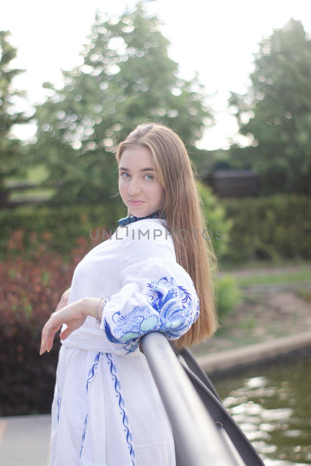 ukrainian blonde girl in national blue dress - embroidered shirt. young woman patriot. outdoors photo of charming female by oliavesna