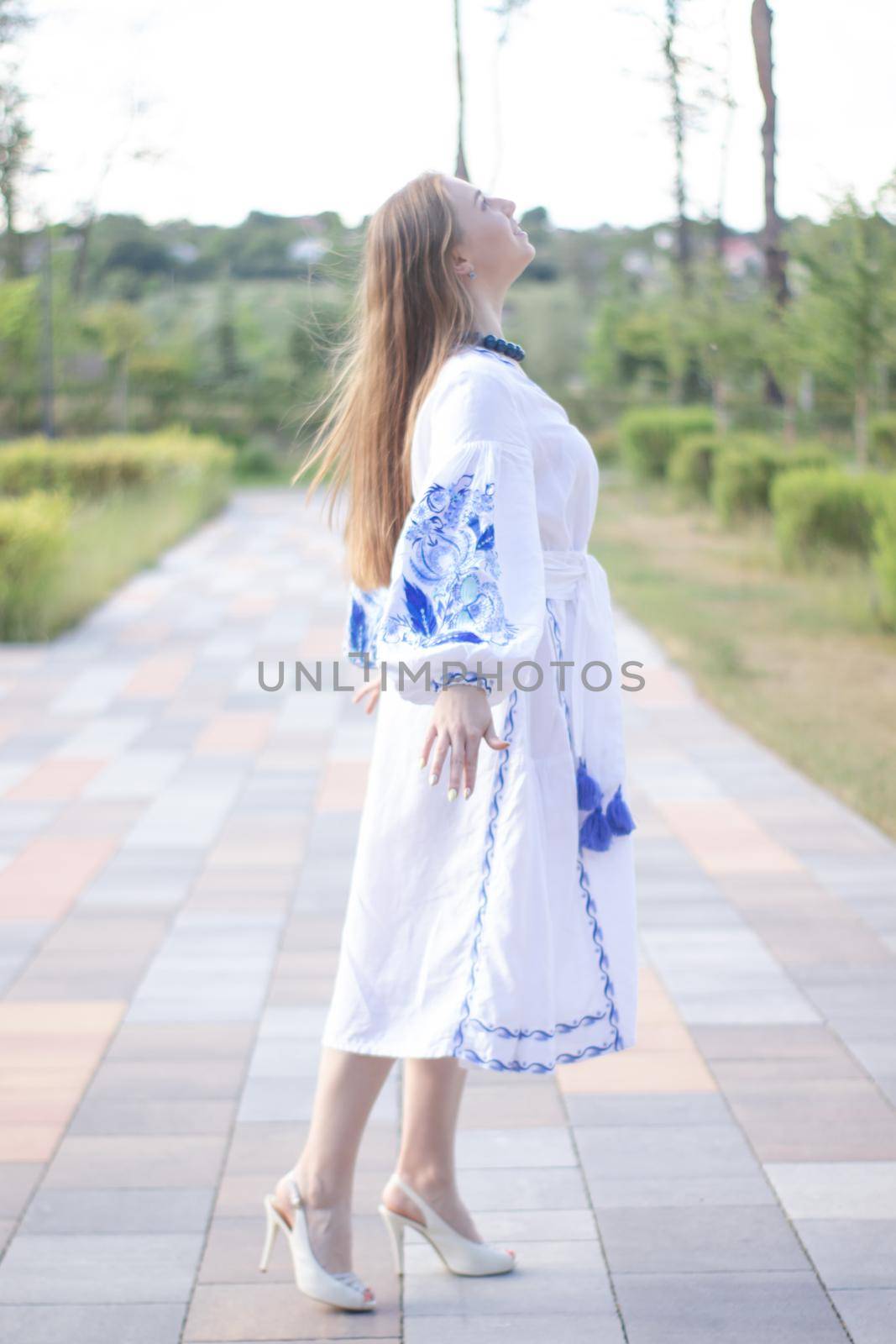 ukrainian blonde girl in national blue dress - embroidered shirt. young woman patriot. outdoors photo of charming female.