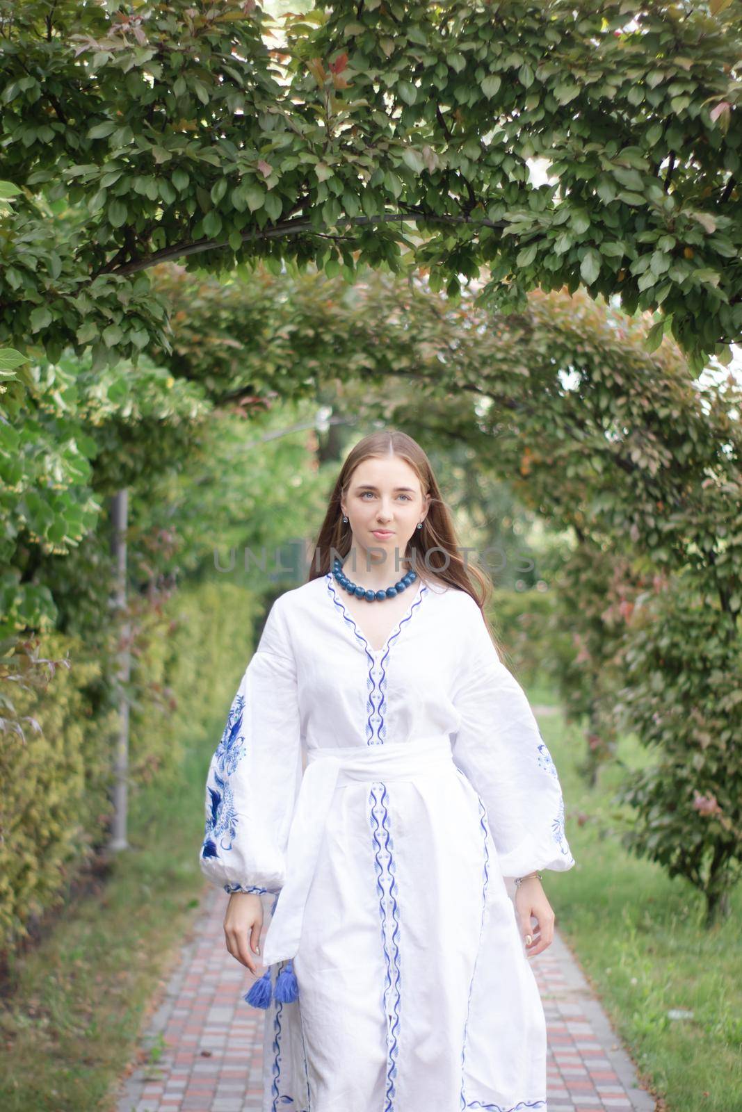 ukrainian blonde girl in national blue dress - embroidered shirt. young woman patriot. outdoors photo of charming female by oliavesna