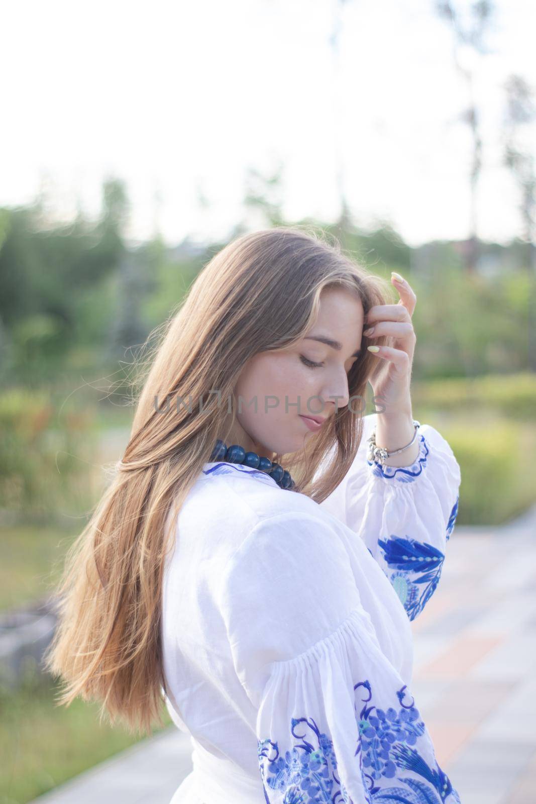 ukrainian blonde girl in national blue dress - embroidered shirt. young woman patriot. outdoors photo of charming female.