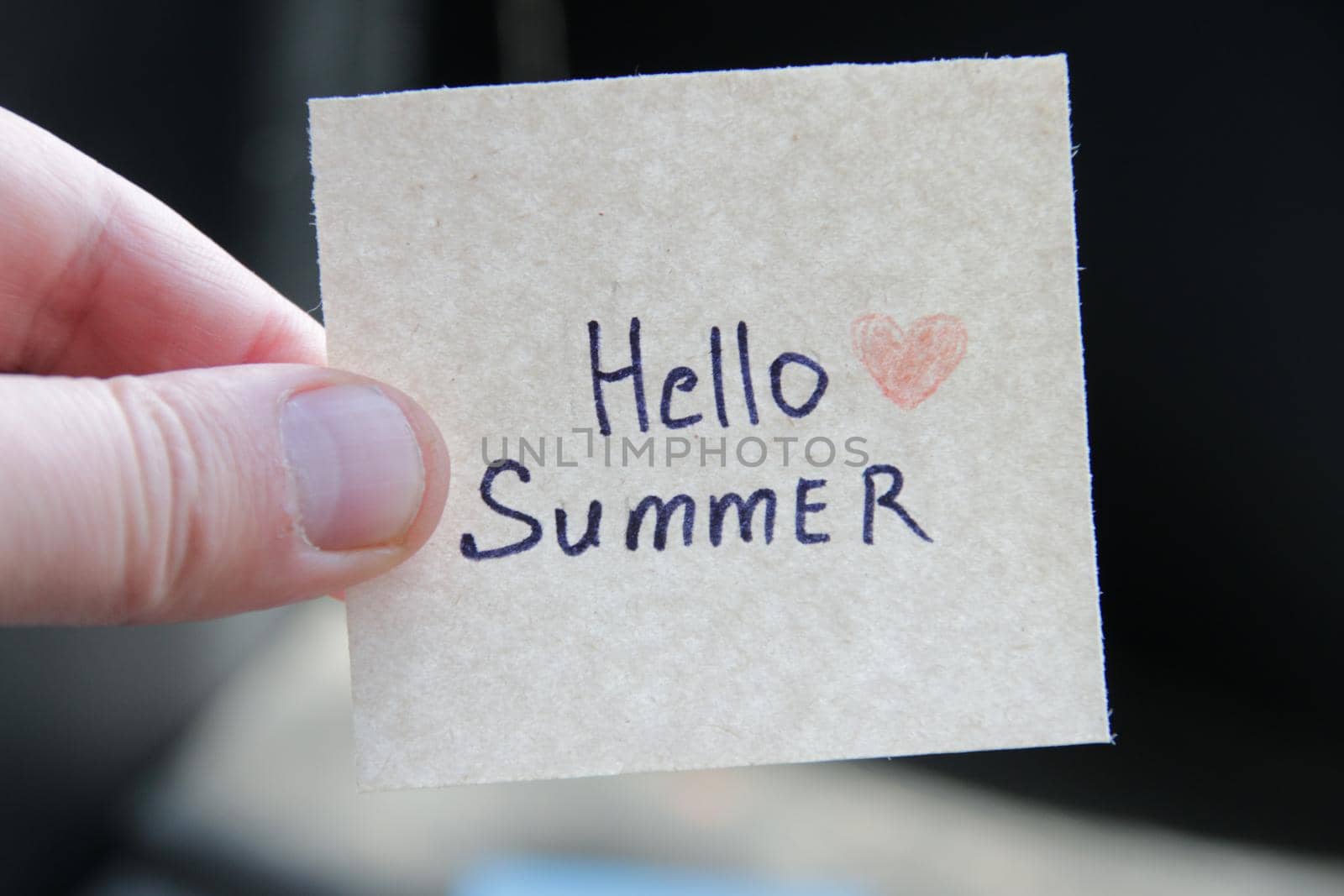 Hello summer. Creative concept. Hand holding a tag with the inscription. High quality photo