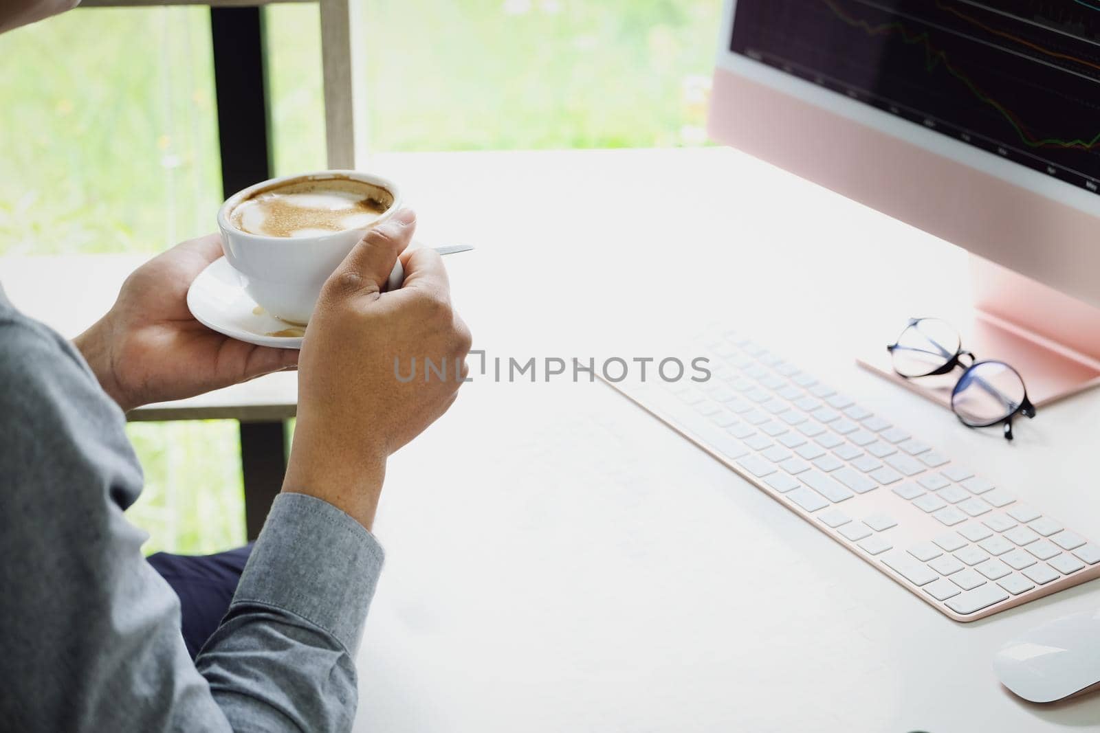 Work from home A company employee holding a coffee cup using a computer to work from home to prevent coronavirus from meeting outsiders