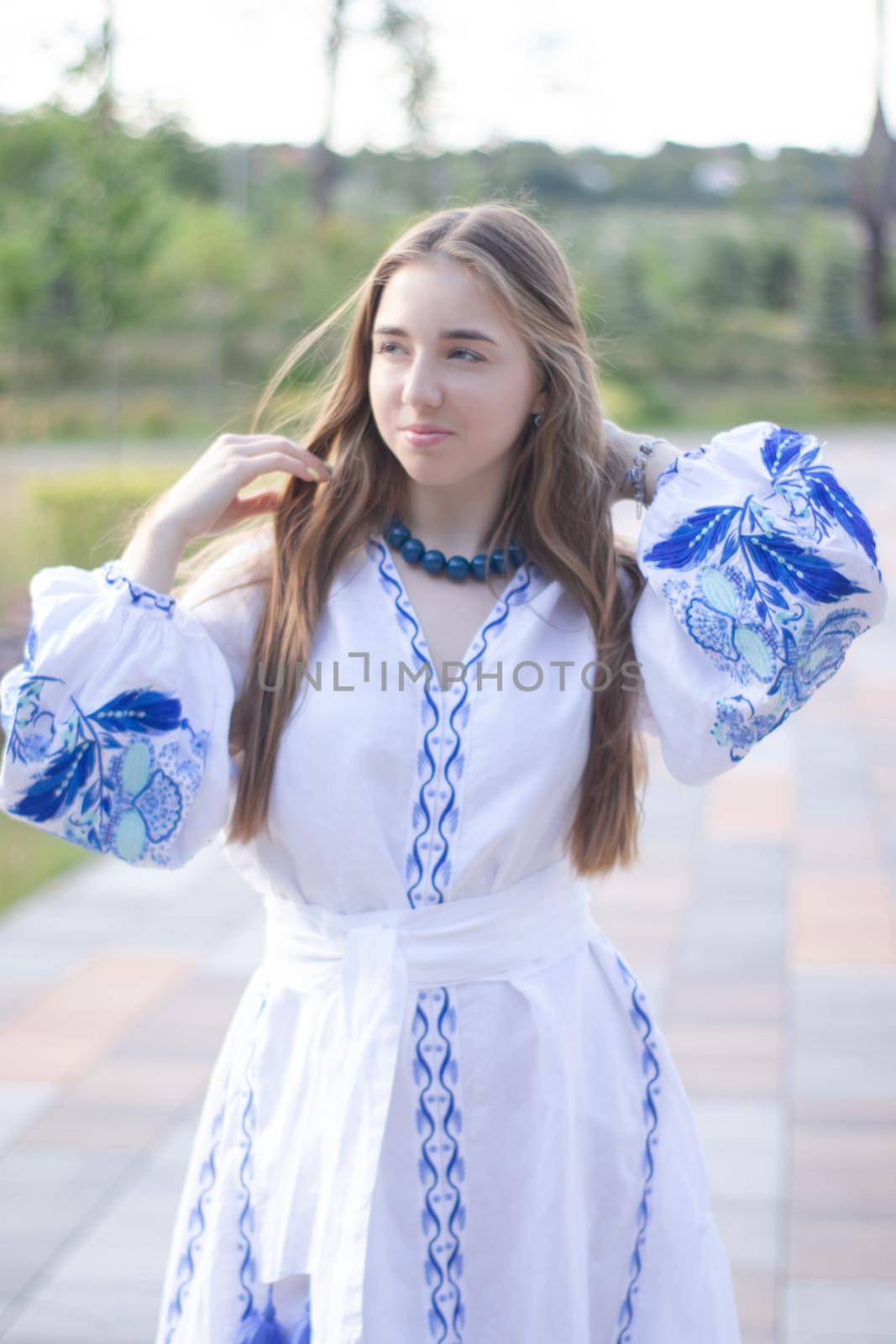 ukrainian blonde girl in national blue dress - embroidered shirt. young woman patriot. outdoors photo of charming female by oliavesna