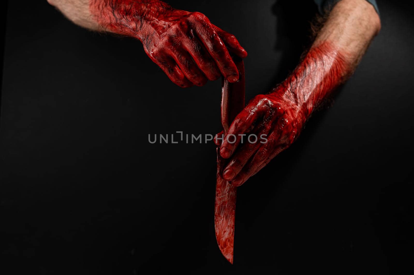 Man holding knife with bloody hand on black background. by mrwed54