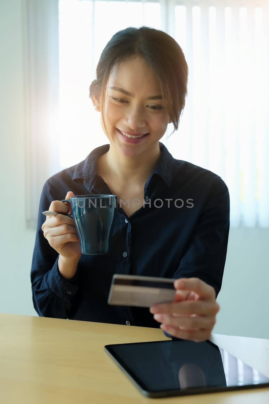 Online payment, Young Women's hands holding credit card and using tablet for online shopping. by Manastrong