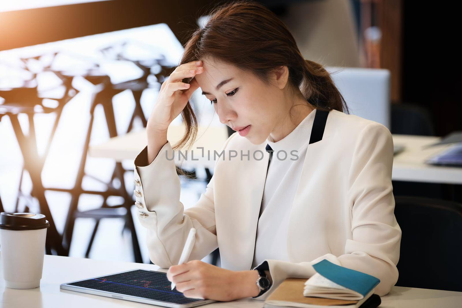 Business woman using tablet to trade charts to find buy and sell points for her port. by Manastrong