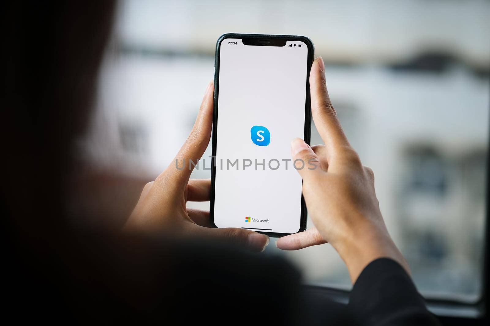 CHIANG MAI, THAILAND - April 06 ,2021: Woman holding iphone with skype apps. Skype is part of Microsoft, can make video, audio calls, chat messages and do much more using Skype by Manastrong