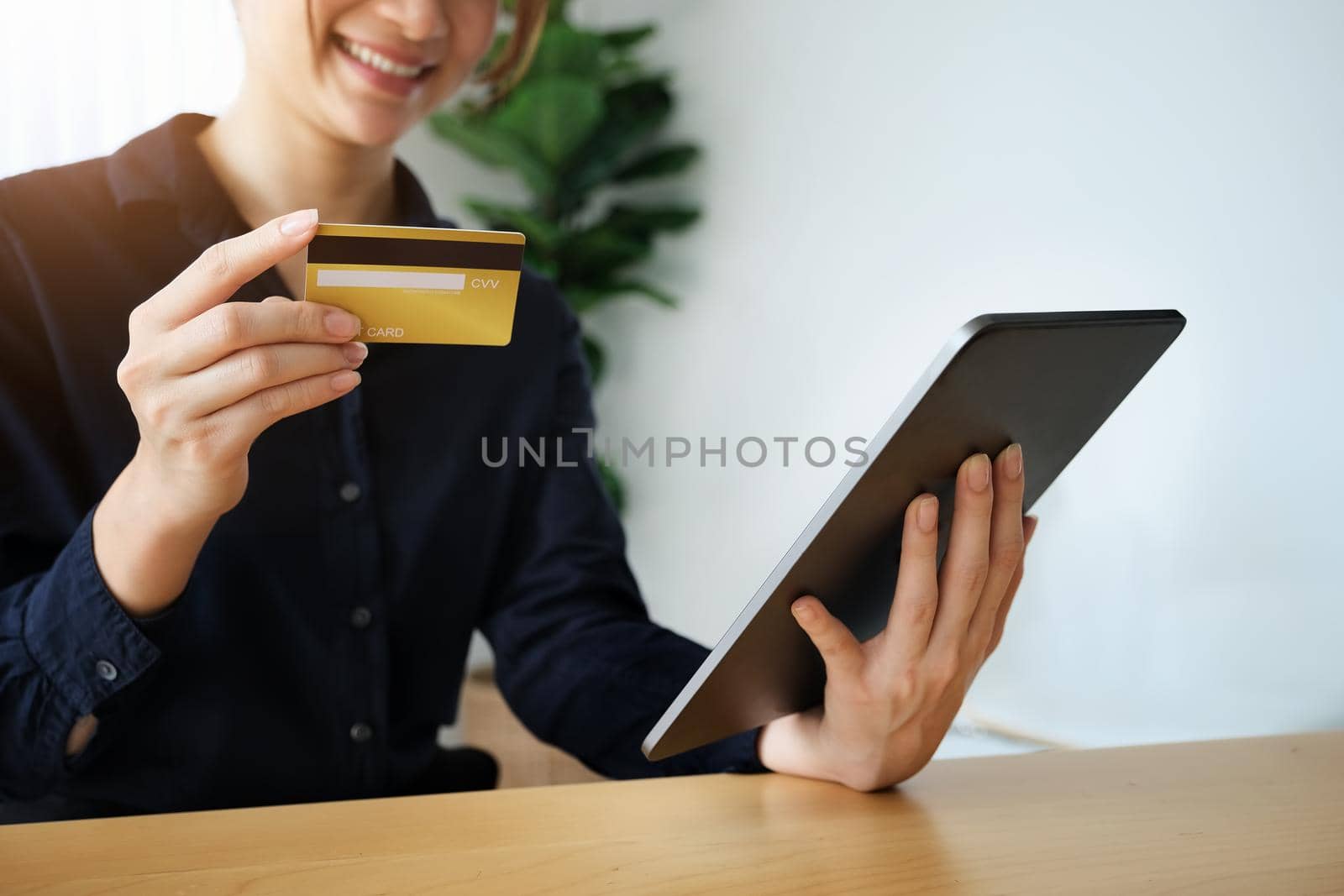 Online payment, Young Women's hands holding credit card and tablet for online shopping. by Manastrong