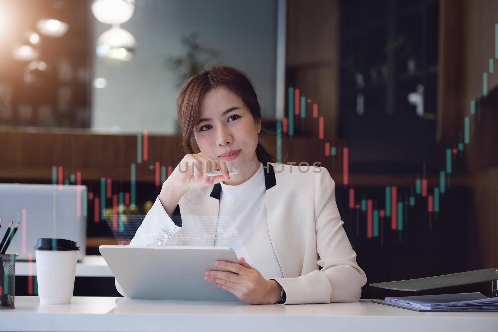 digital technology, Business woman using tablet to trade charts to find buy and sell points for her port.