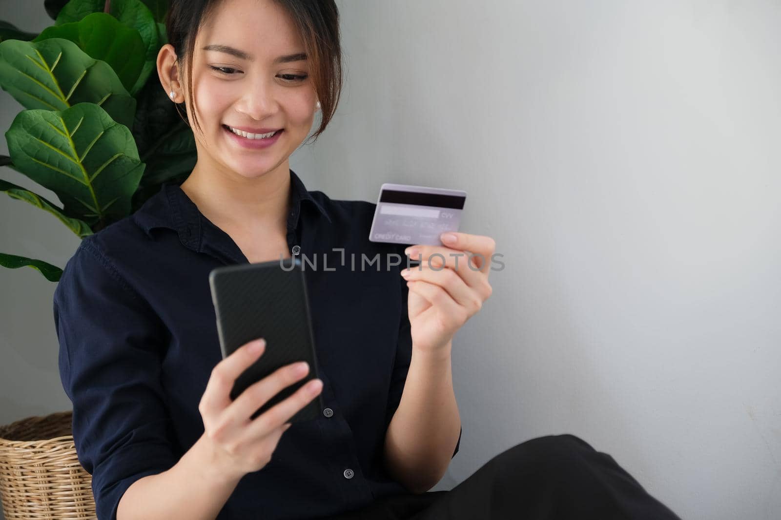 Online payment, Young Women's hands holding credit card and using smartphone for online shopping at home by Manastrong