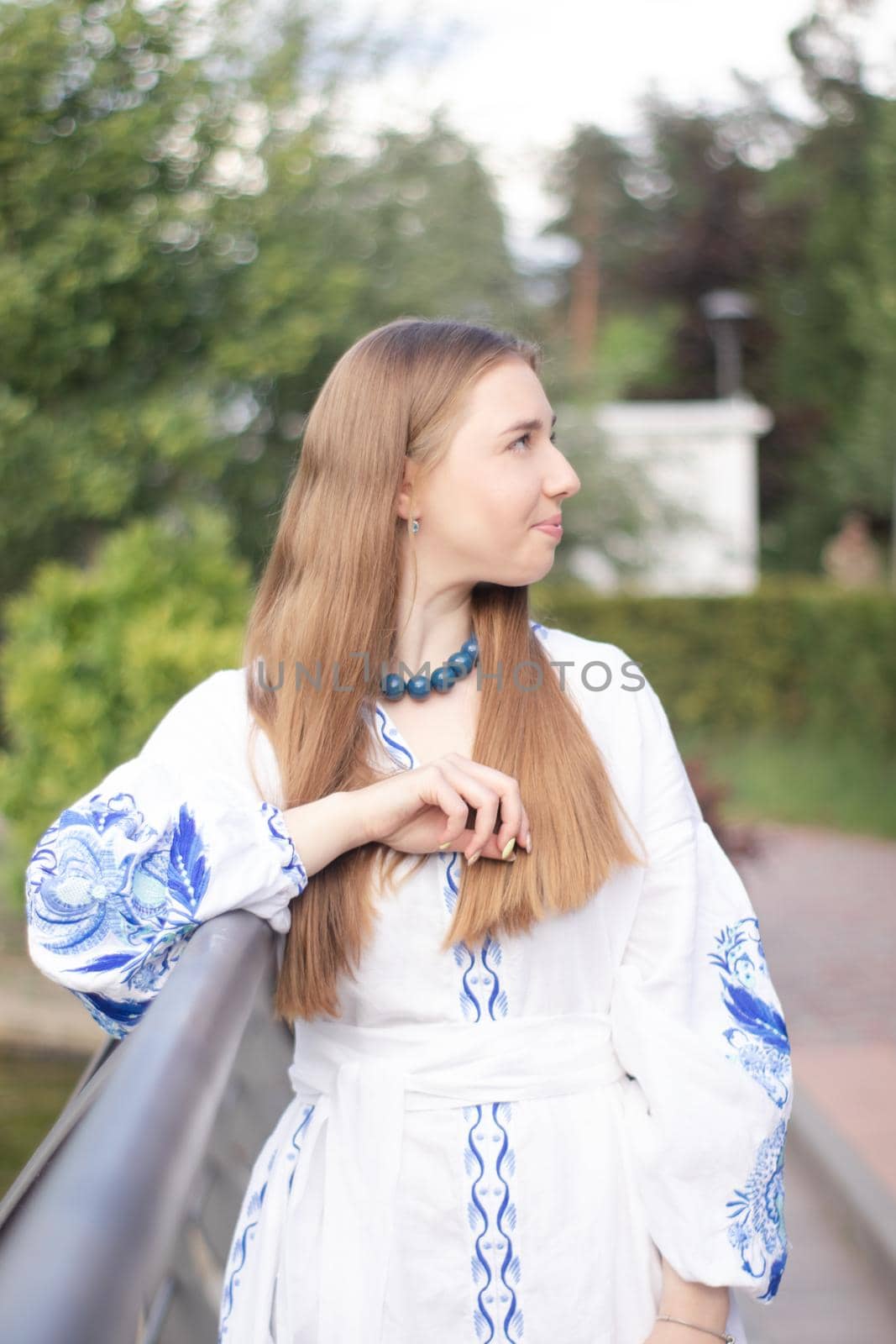 ukrainian blonde girl in national blue dress - embroidered shirt. young woman patriot. outdoors photo of charming female.
