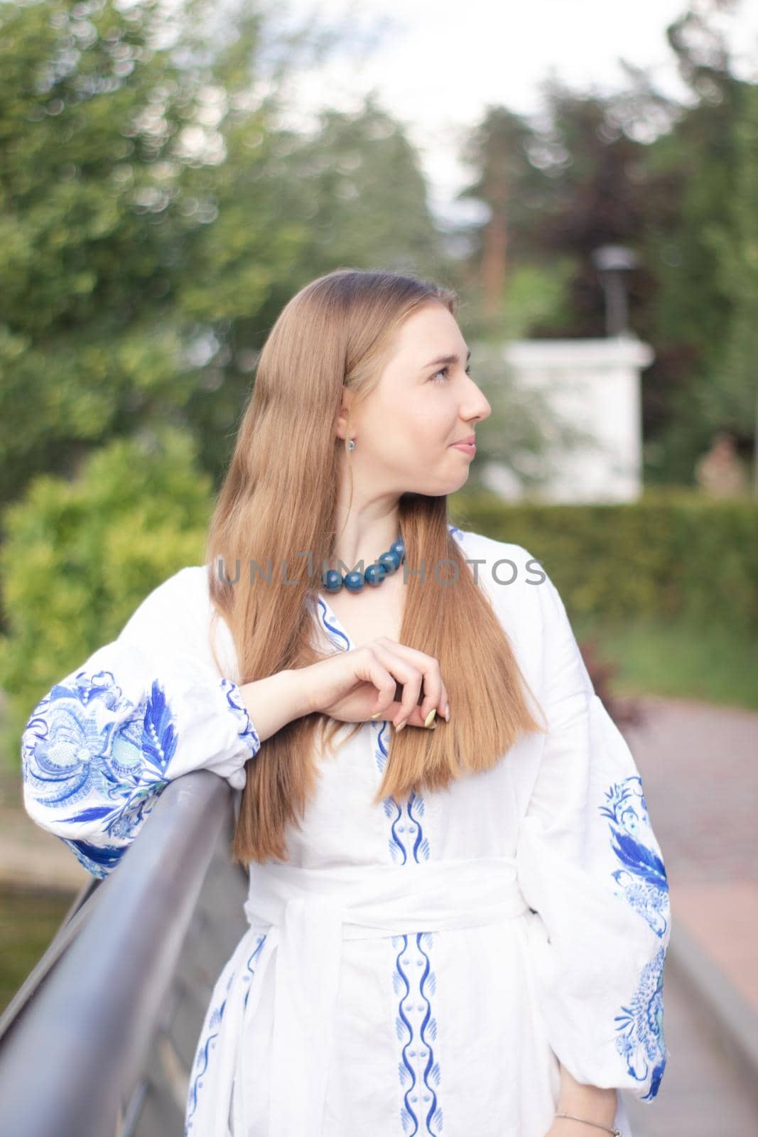 ukrainian blonde girl in national blue dress - embroidered shirt. young woman patriot. outdoors photo of charming female by oliavesna