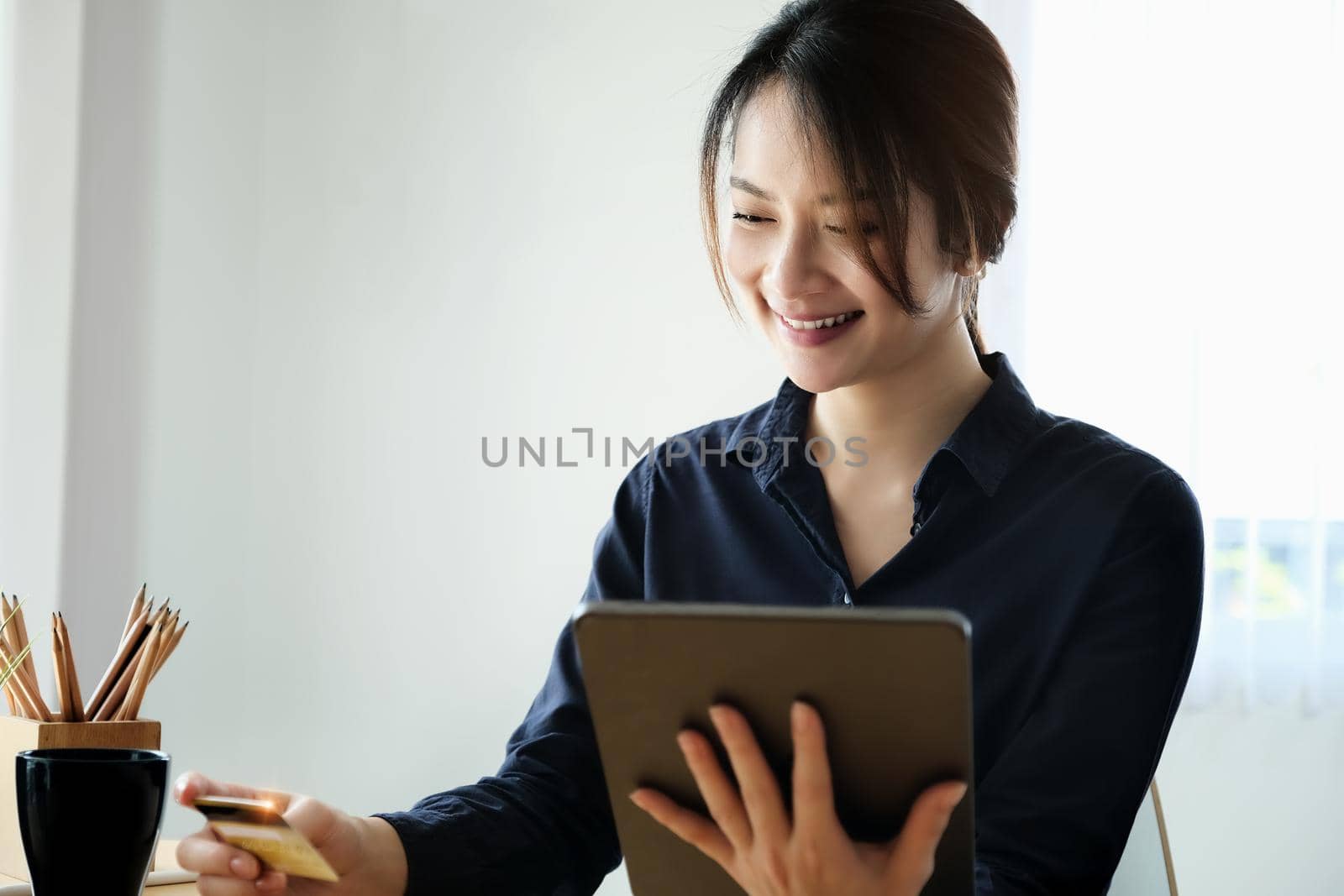 Online payment, Young Women's hands holding tablet and credit card for online shopping. by Manastrong