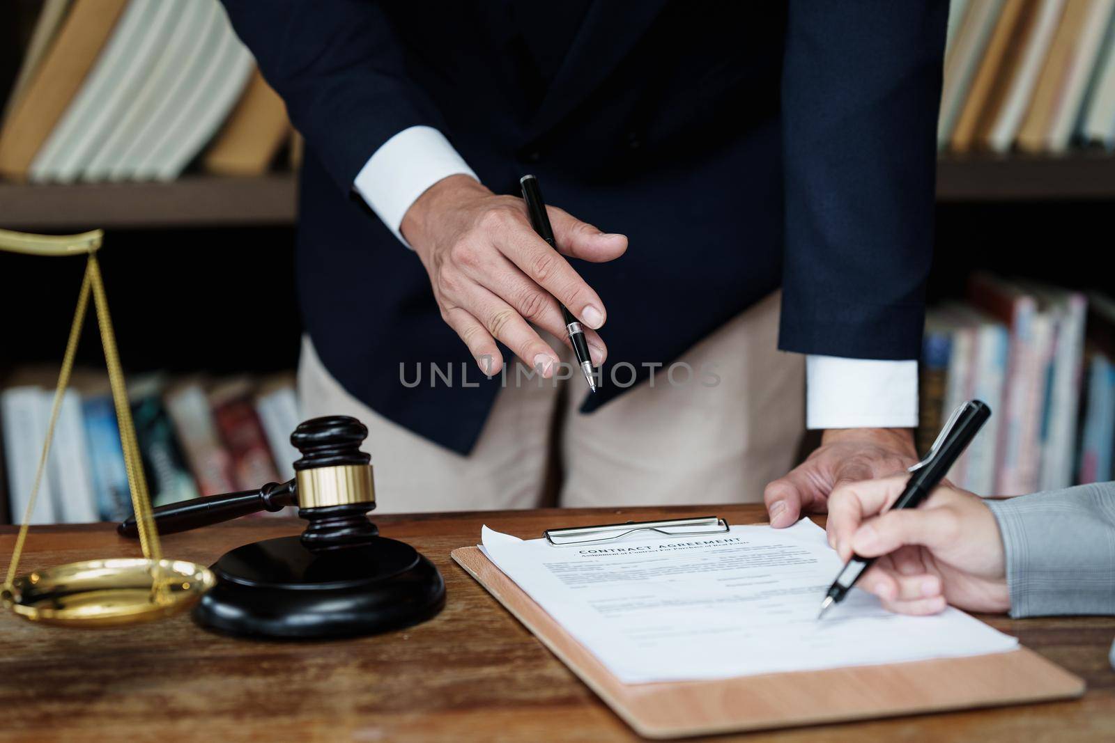 Business woman and lawyers discussing contract papers with brass scale on wooden desk in office. Law, legal services, advice, Justice concept