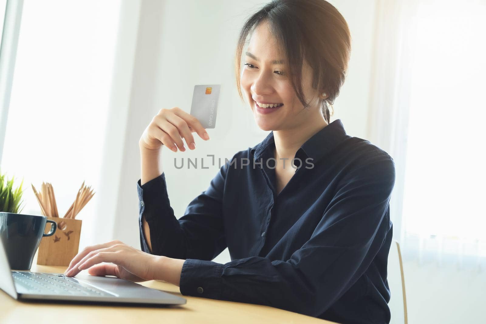 Online payment, Young Women's using computer and hands holding credit card for online shopping. by Manastrong