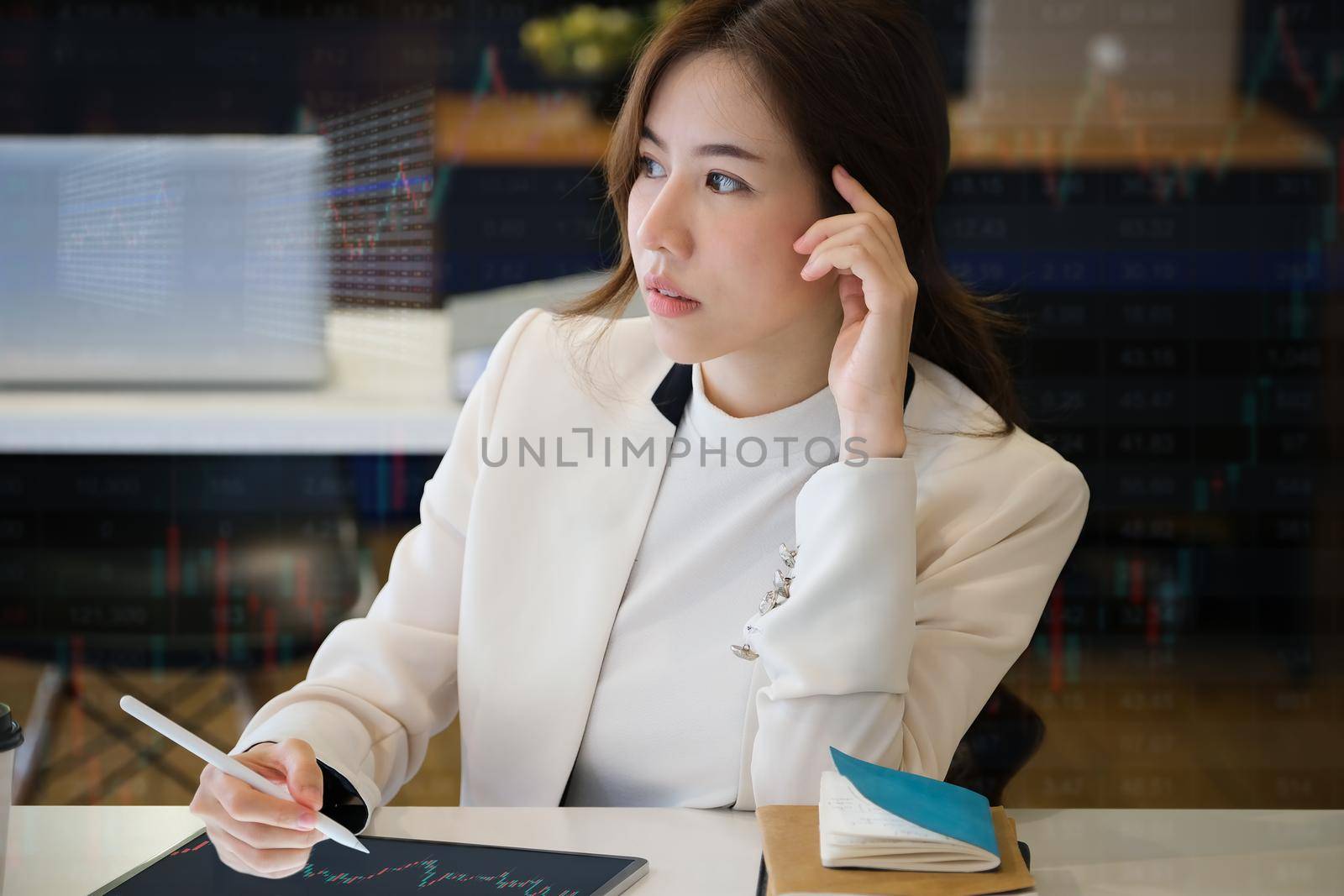 Business woman using tablet to trade charts to find buy and sell points for her port