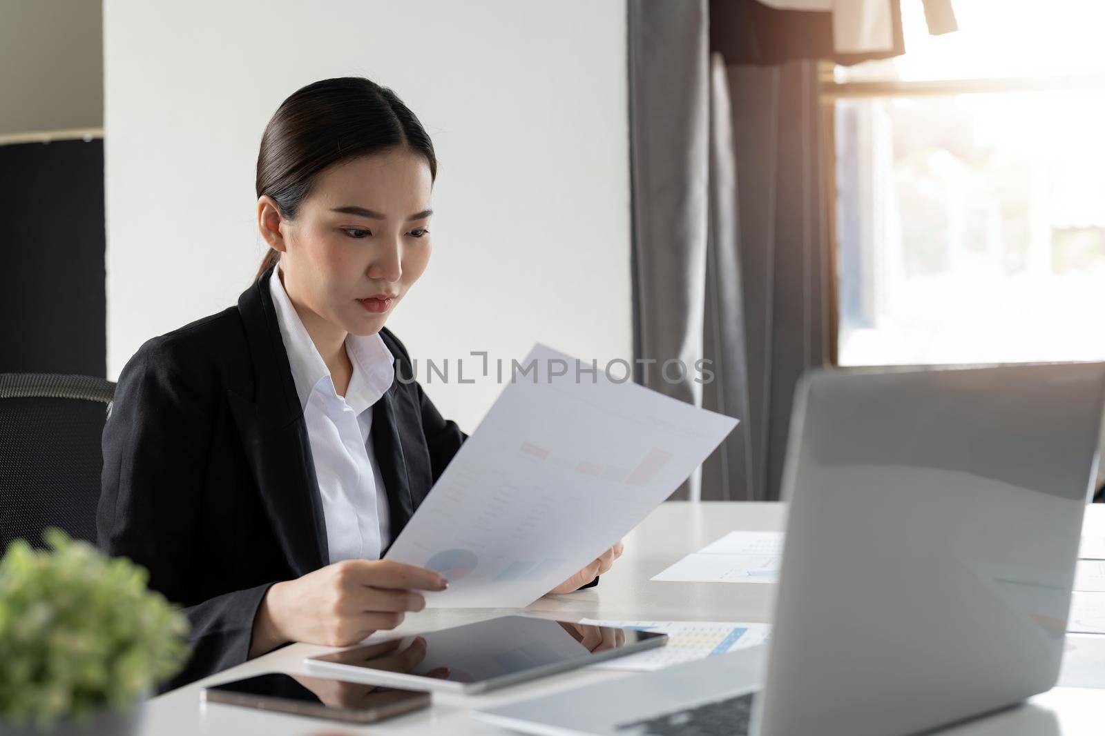 business woman or accountant working on calculator to calculate business data, accountancy document and laptop computer at office, business concept.