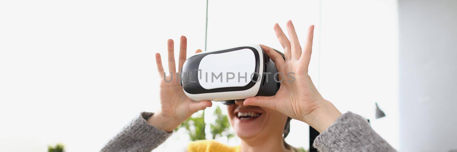 Close-up of woman wear vr glasses modern device at home and laugh. Visual effects, fun pastime, adventure time. Innovation, entertainment, leisure concept