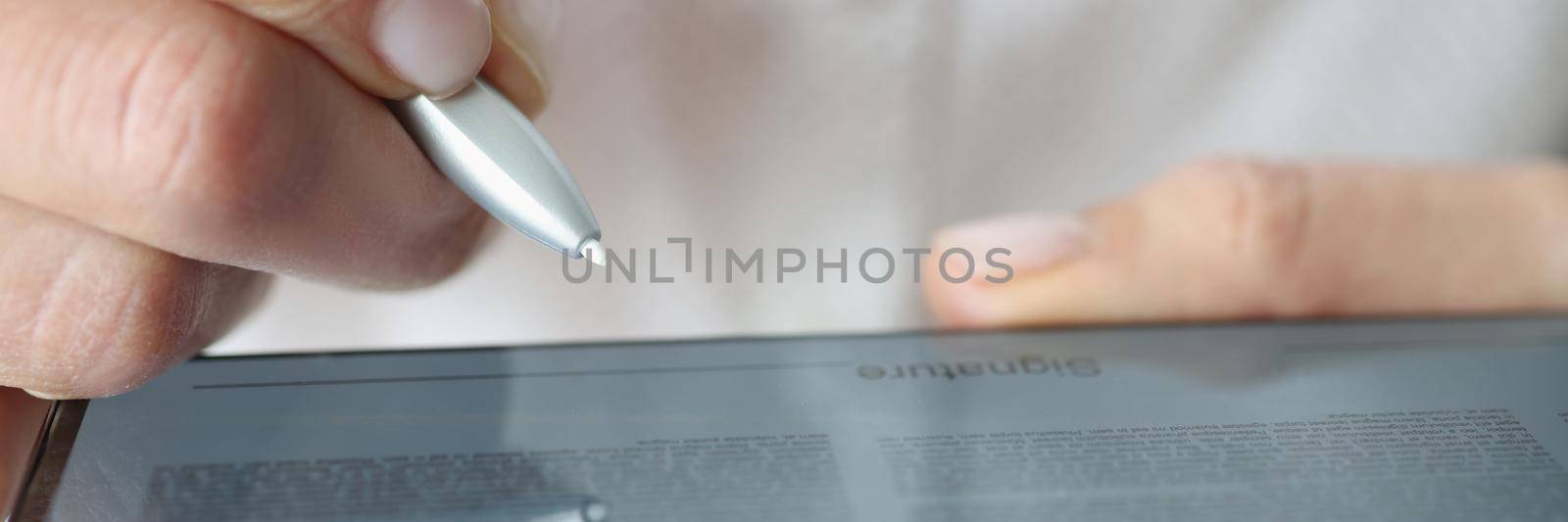 Man put signature on digital tablet device, open document and space for signing by kuprevich