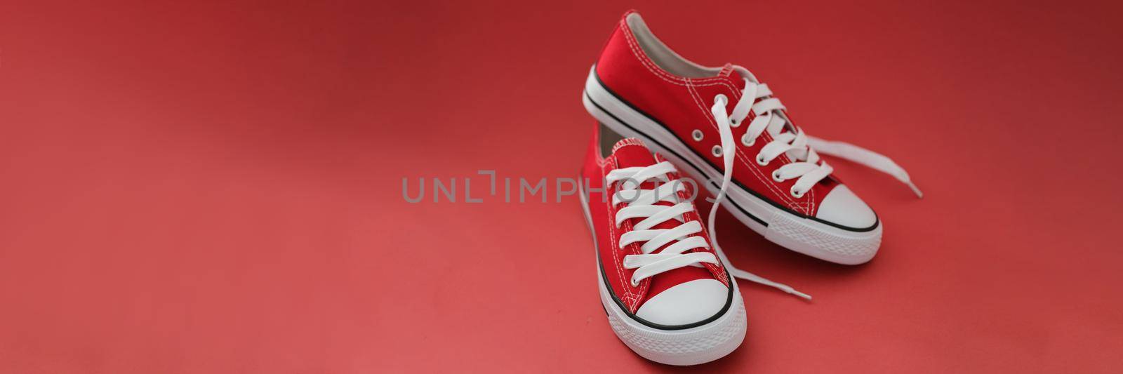Pair of modern stylish red sneaker shoes, white and red colours mix, new collection by kuprevich