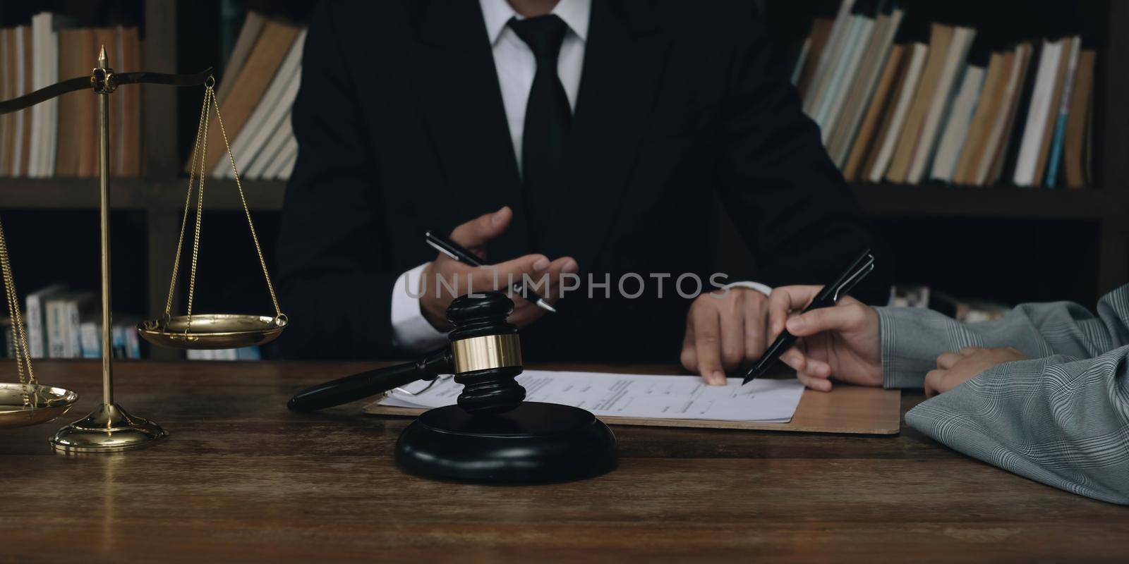 Business woman and lawyers discussing contract papers with brass scale on wooden desk in office. Law, legal services, advice, Justice concept..